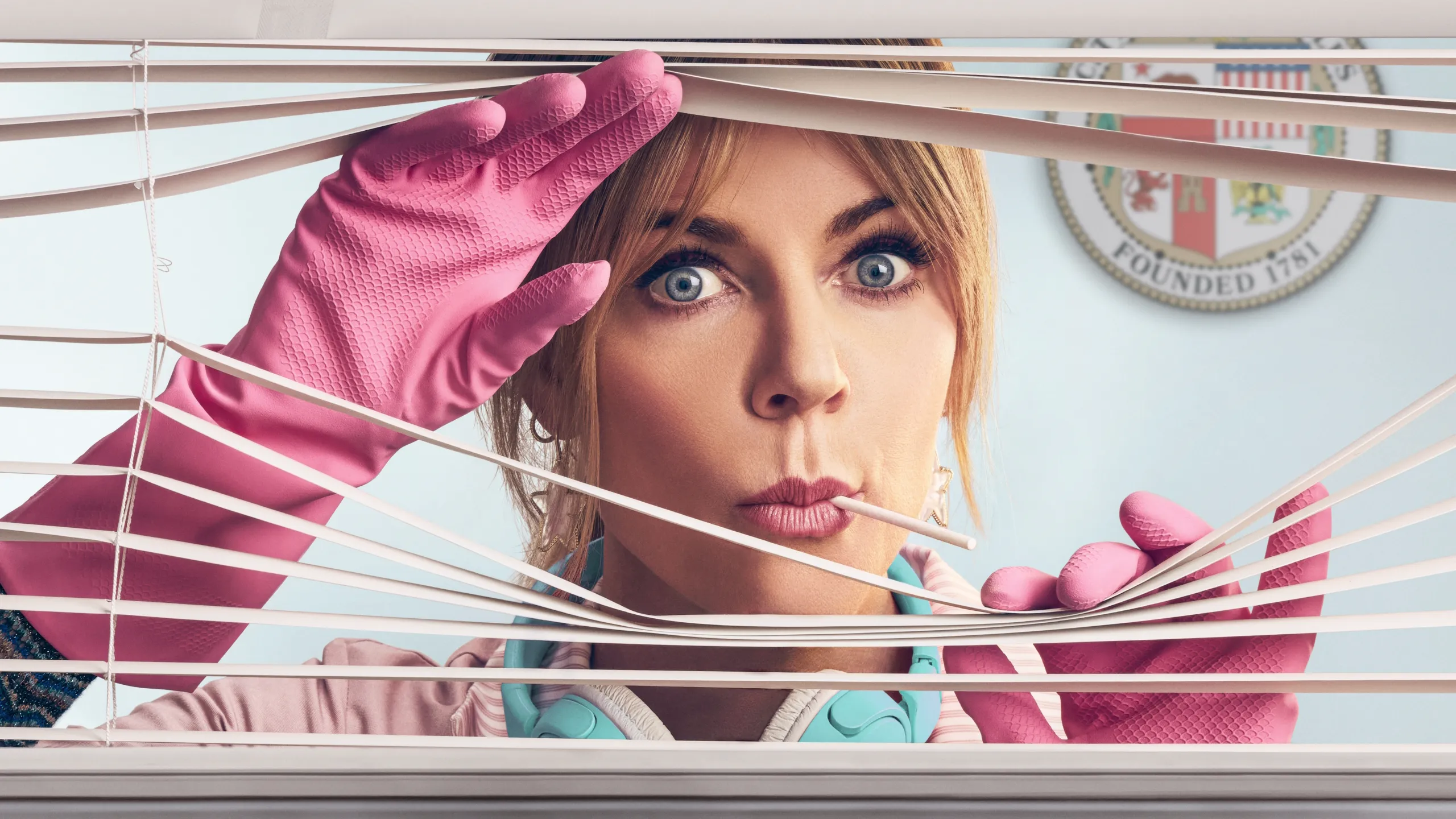 Kaitlin Olson as Morgan Gillory peeking through window blinds wearing pink cleaning gloves in promotional imagery for High Potential