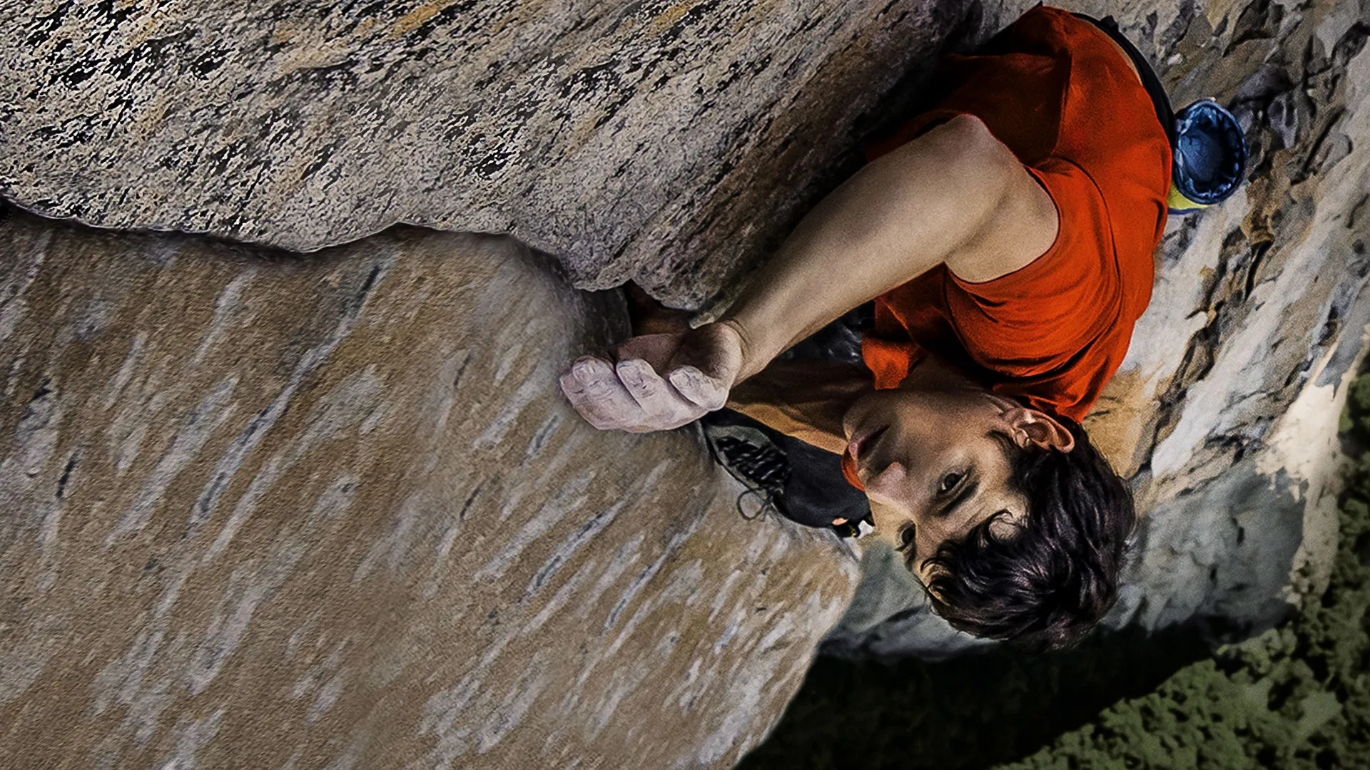 This image shows professional rock climber Alex Honnold ascending a sheer rock face without the use of ropes or safety gear.