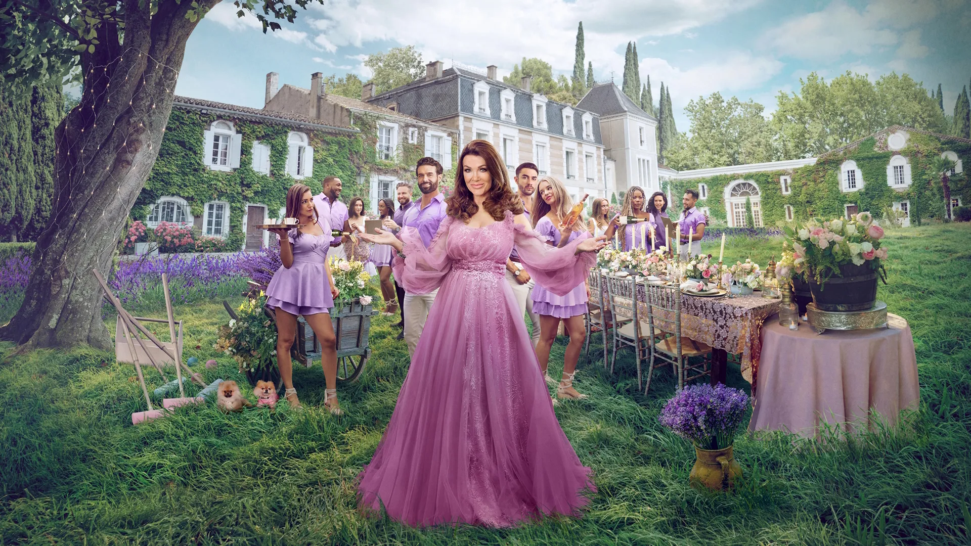 Lisa Vanderpump wearing a pink dress, standing in front of a chateau surrounded by her staff