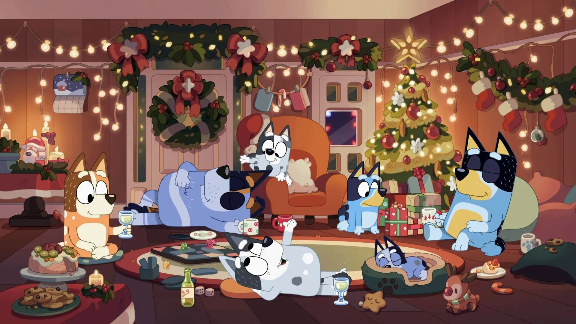 Bluey's family sits in a room decorated for Christmas, eating, drinking, and playing a board game.