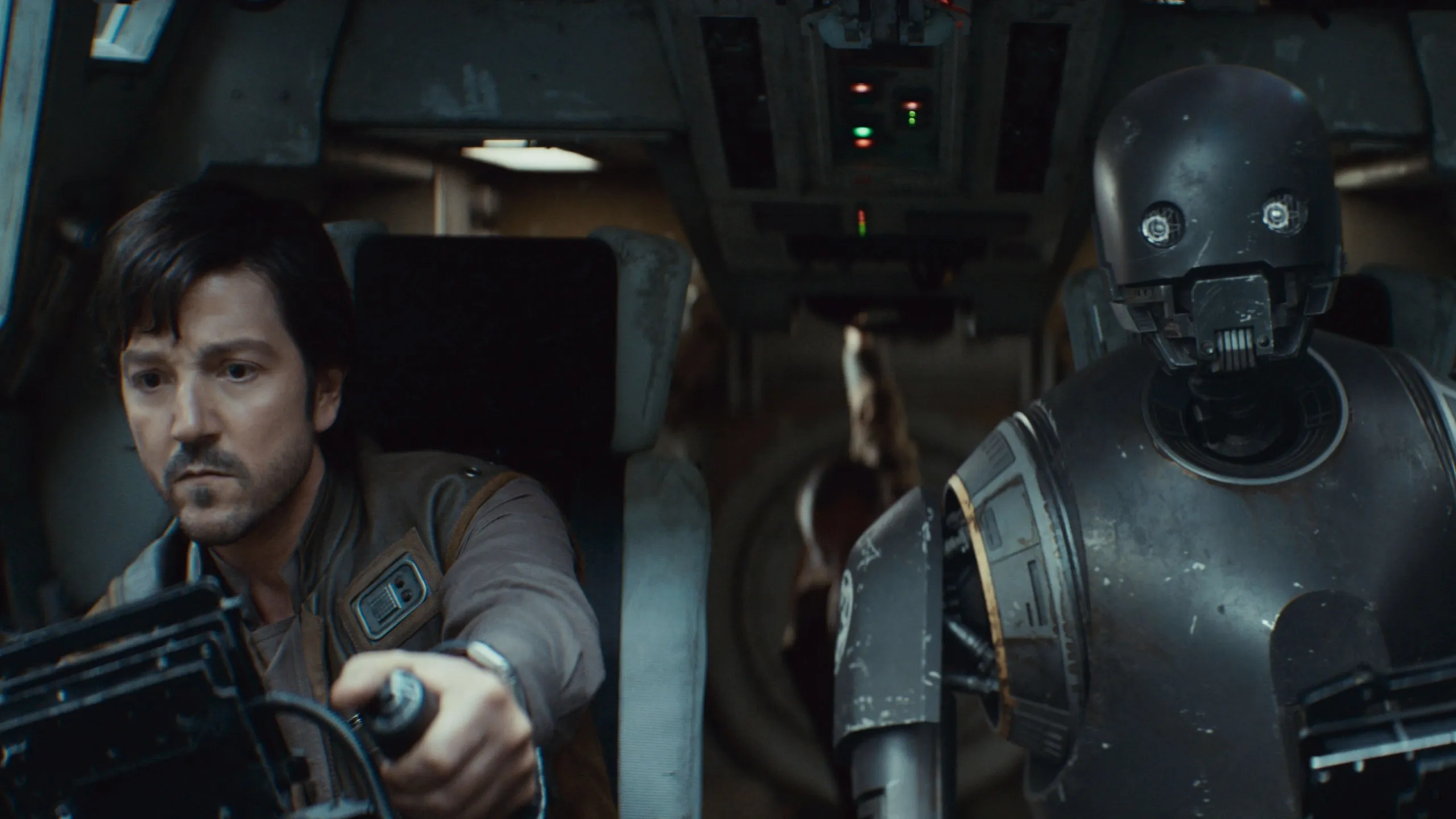 Cassian Andor and K-2SO flying a ship.