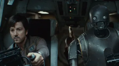 Cassian Andor and K-2SO flying a ship.