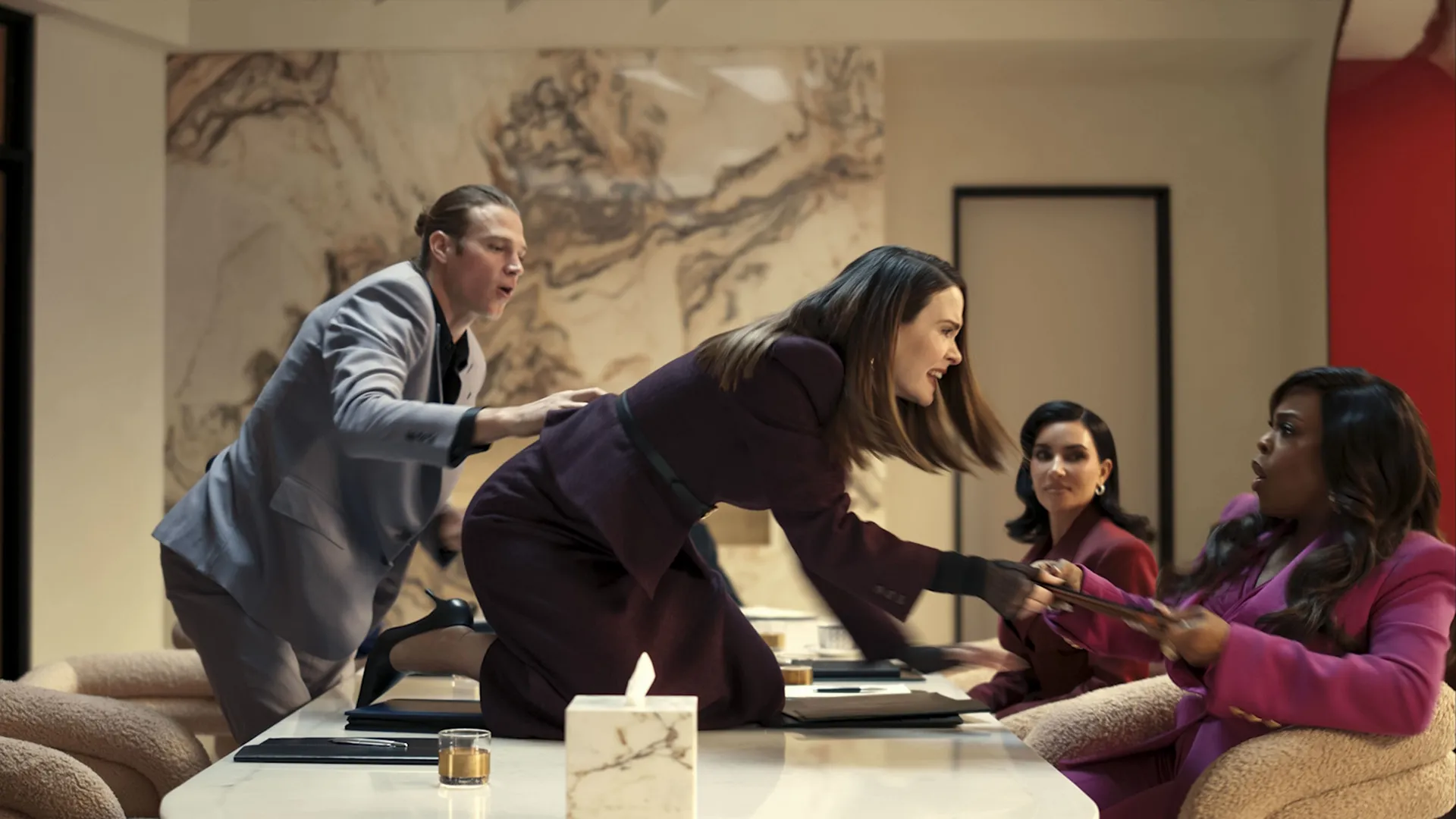 Sarah Paulson as Carrington Lane climbing onto a conference room table to attack Emerald Greene, played by Niecy Nash-Betts