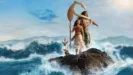 A live-action Moana stands holding a paddle next to Maui on a rocky outcrop surrounded by crashing ocean waves, accompanied by the rooster Heihei and the pig Pua.