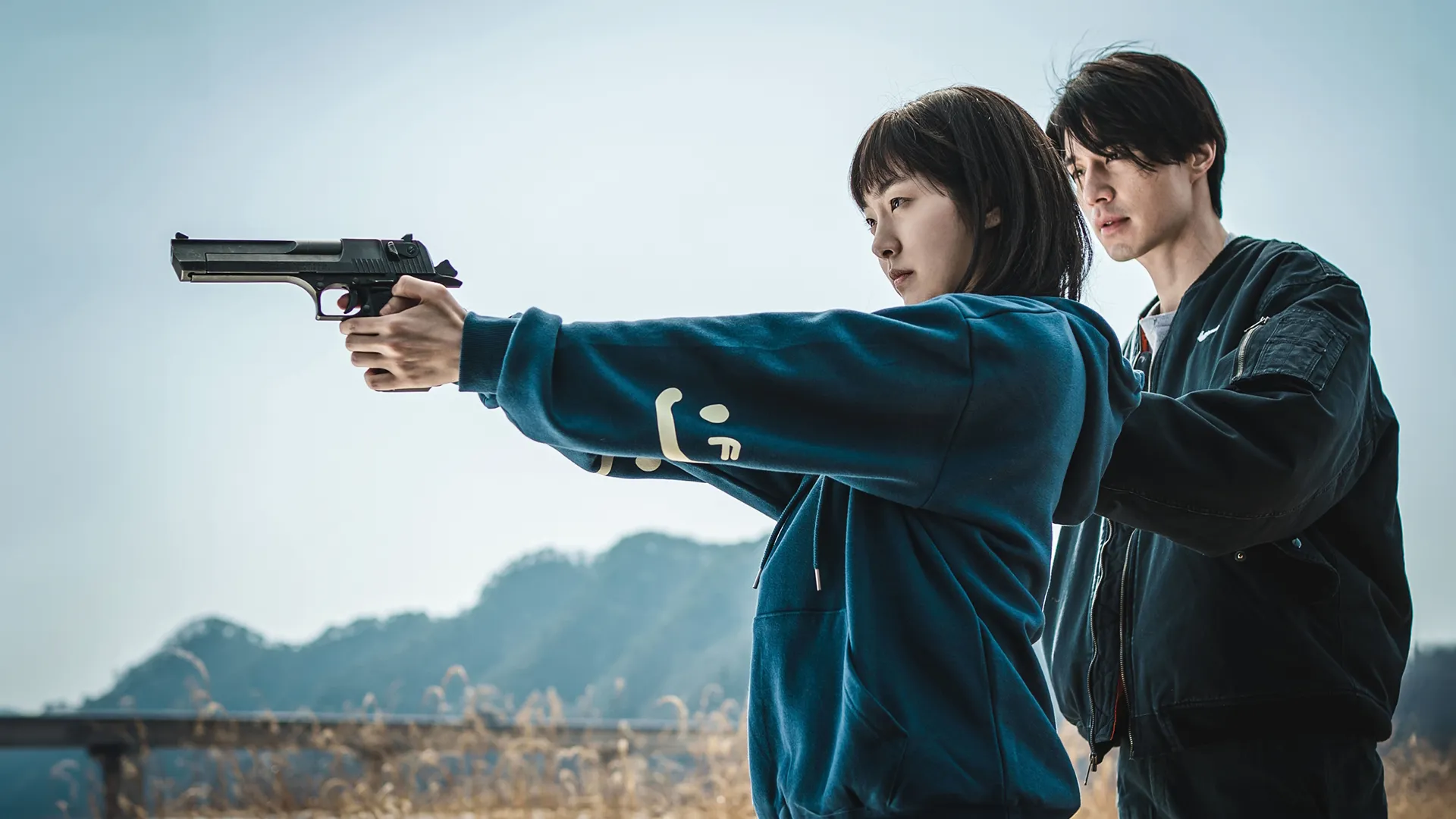 Jung Ji-an (Kim Hye-jun) holds a handgun in both hands.