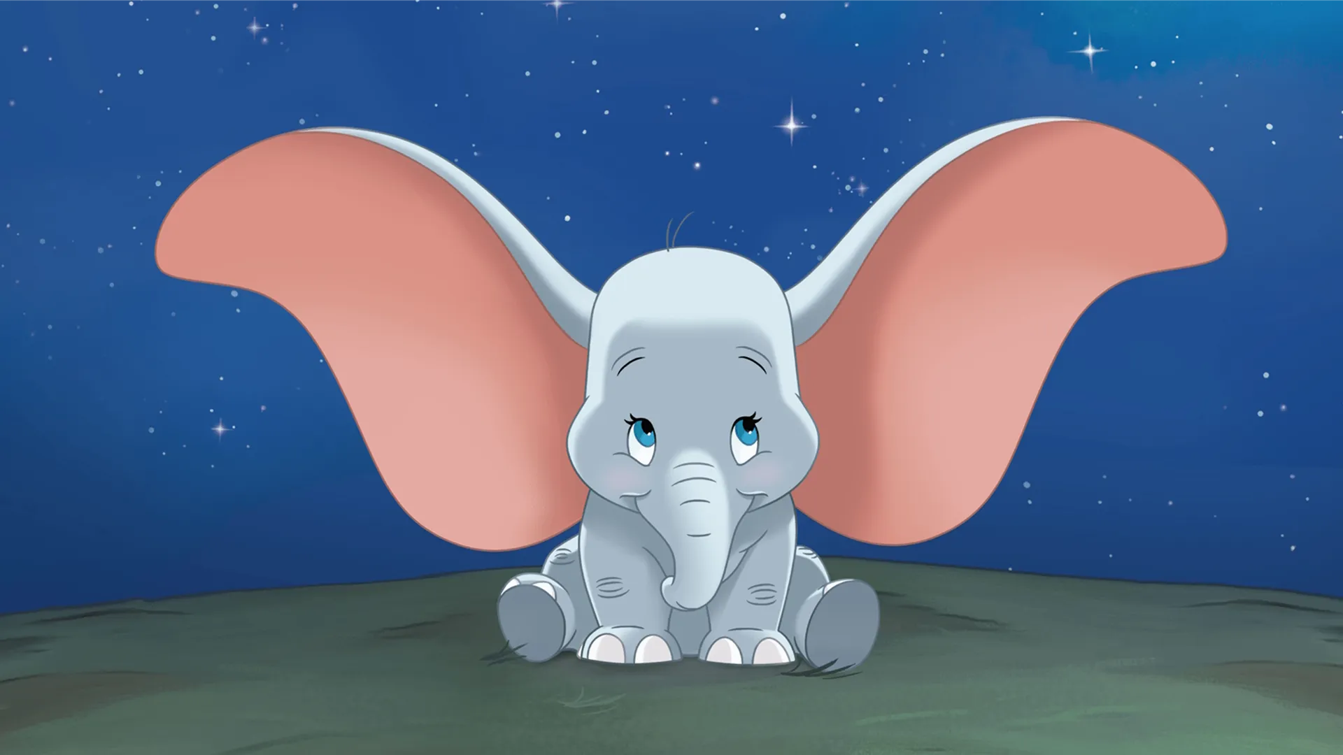Dumbo sits on the ground beneath a starry night sky.