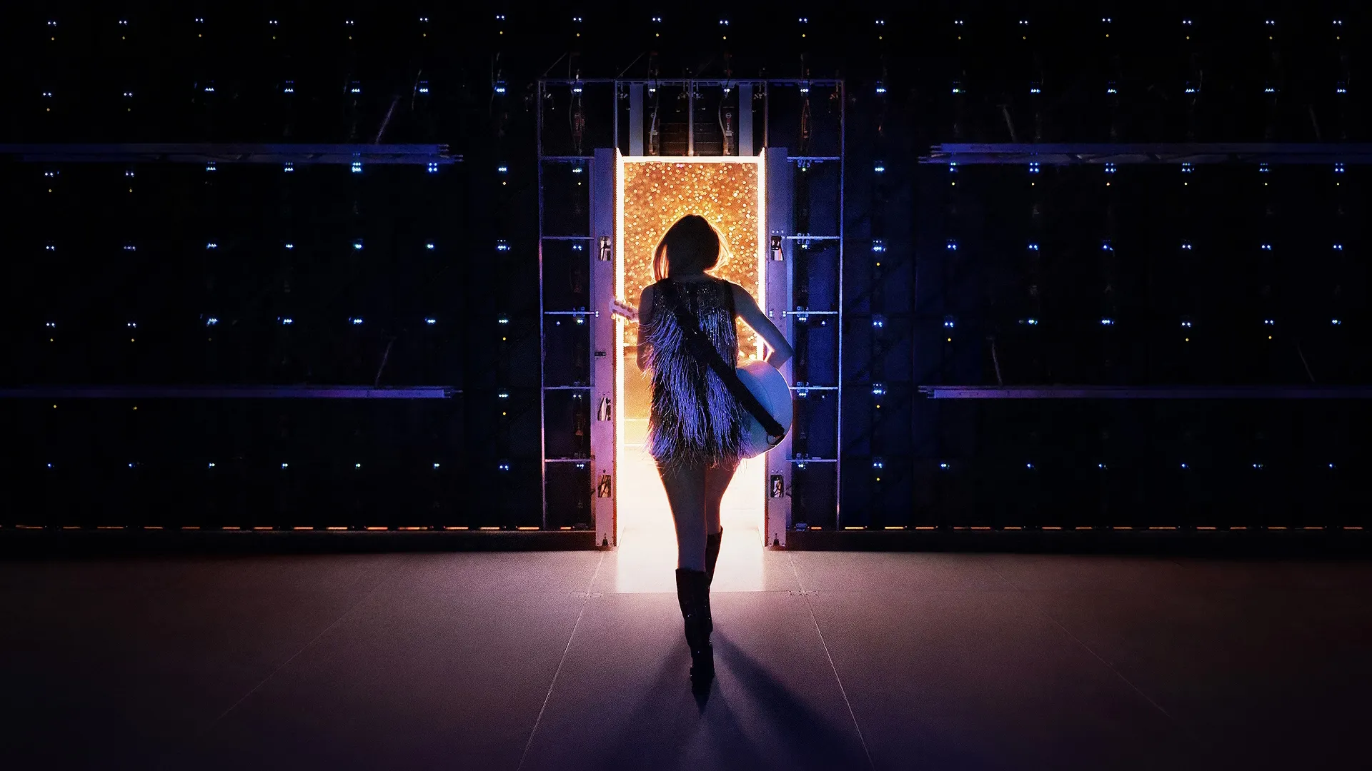 Taylor Swift walks towards a doorway to the stage.