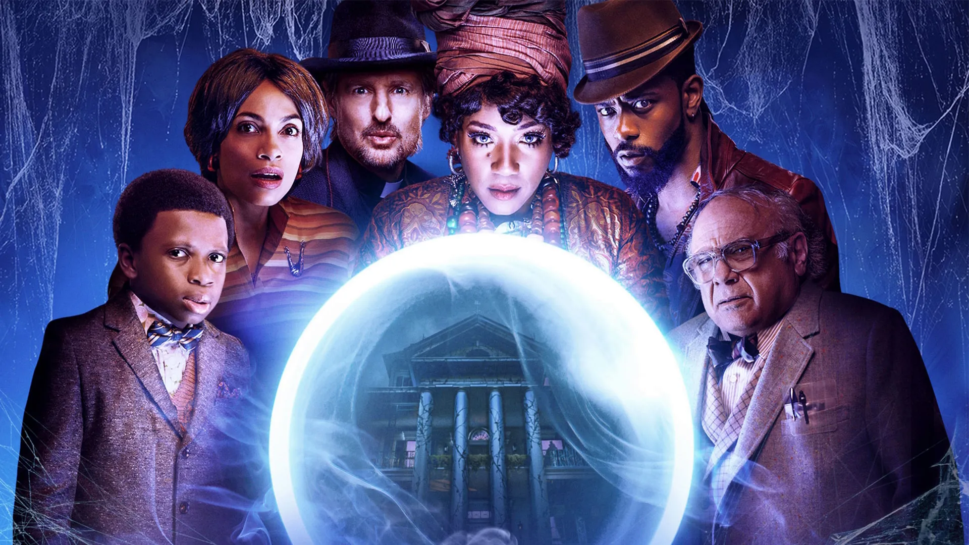 A promotional poster for the 2023 movie Haunted Mansion shows six main characters gathering around a large, glowing crystal ball that reveals a mansion inside, all set against a dark blue background draped in cobwebs.
