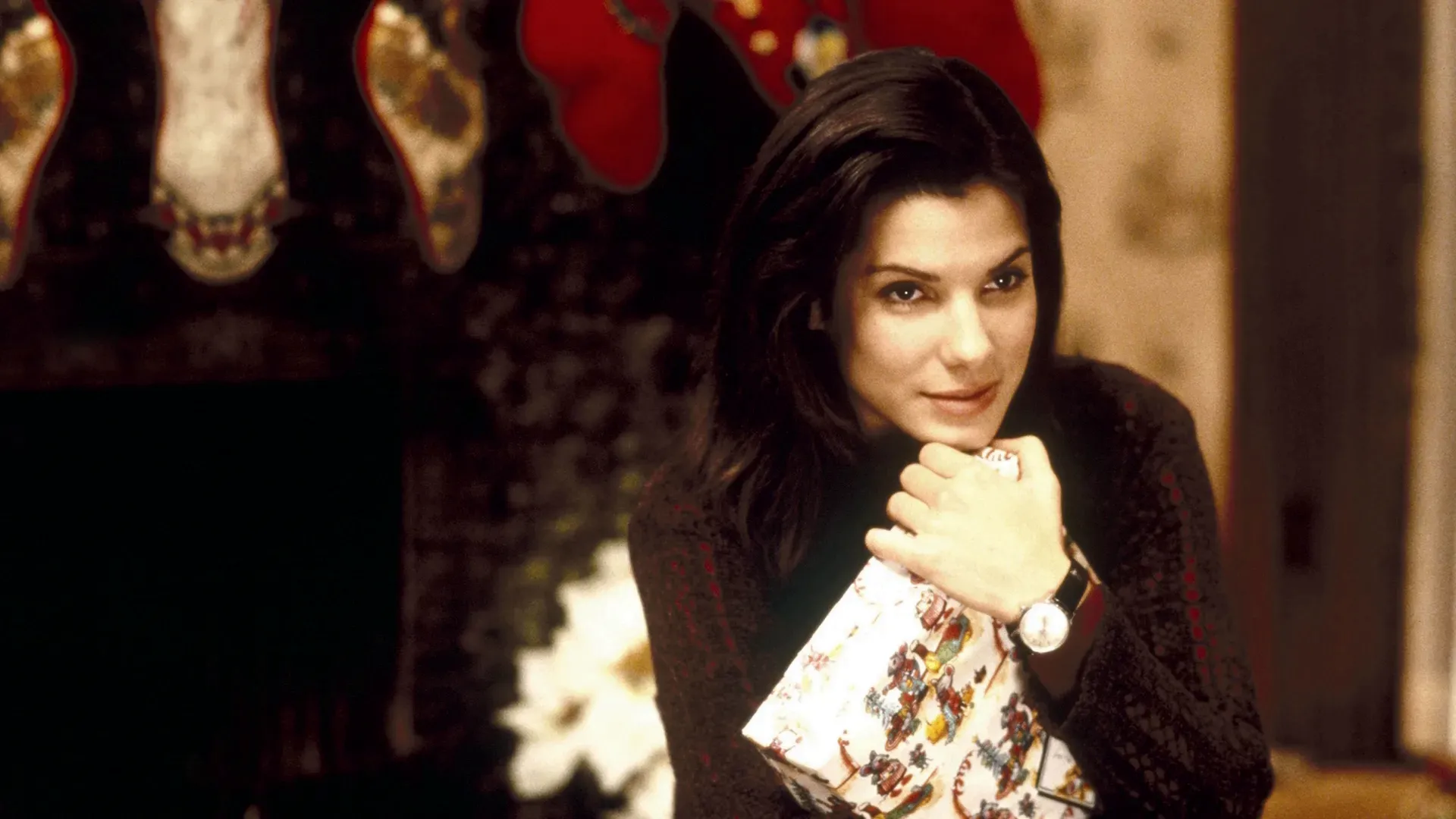 Lucy (Sandra Bullock) looking just right of camera, clutching a wrapped present.
