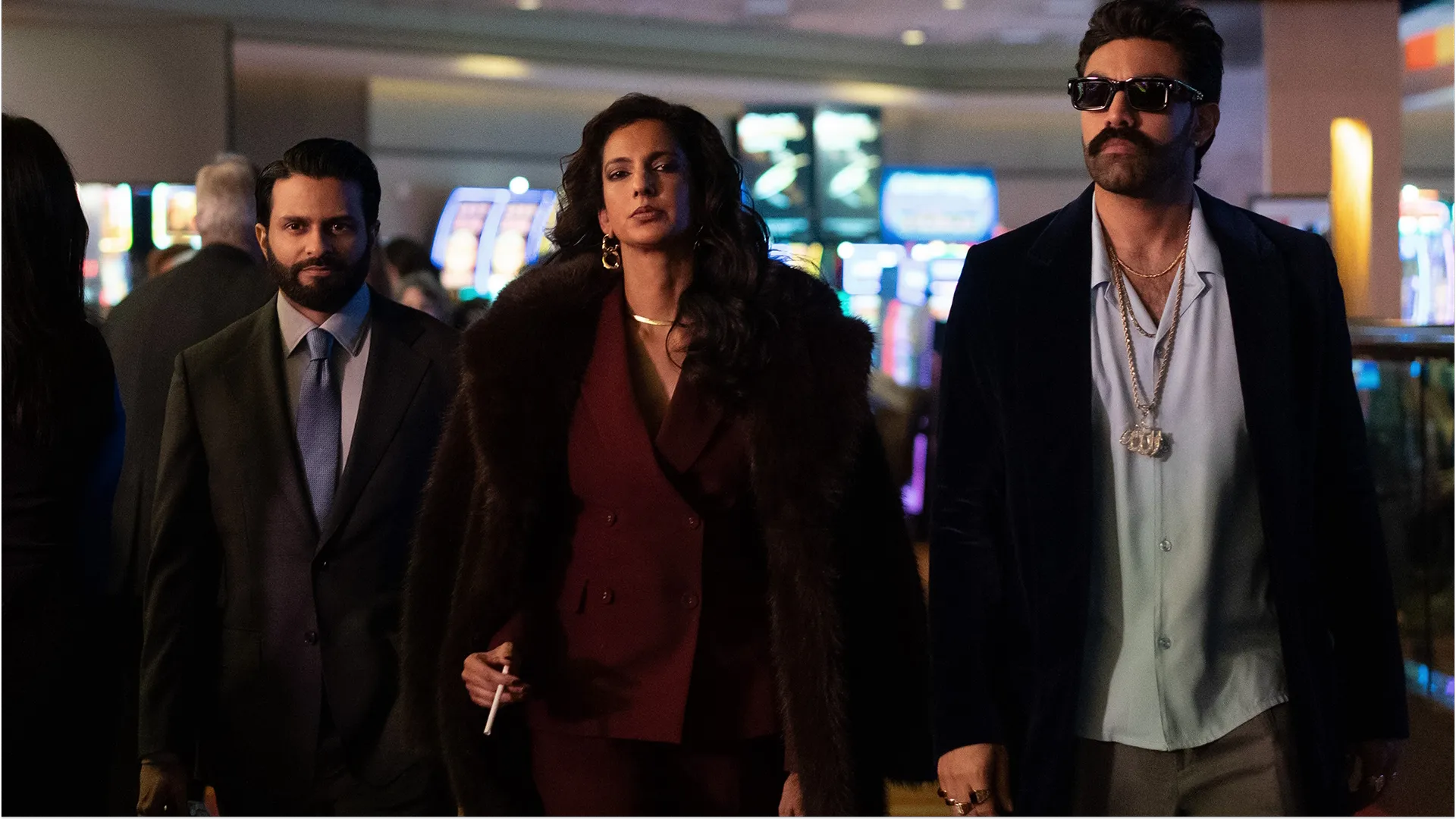 The faces of Lucky (Poorna Jagannathan), Max Sugar (Fred Armisen), Mir (Asif Ali), and Raj (Saagar Shaikh) peer out of a pile of bank notes and poker chips