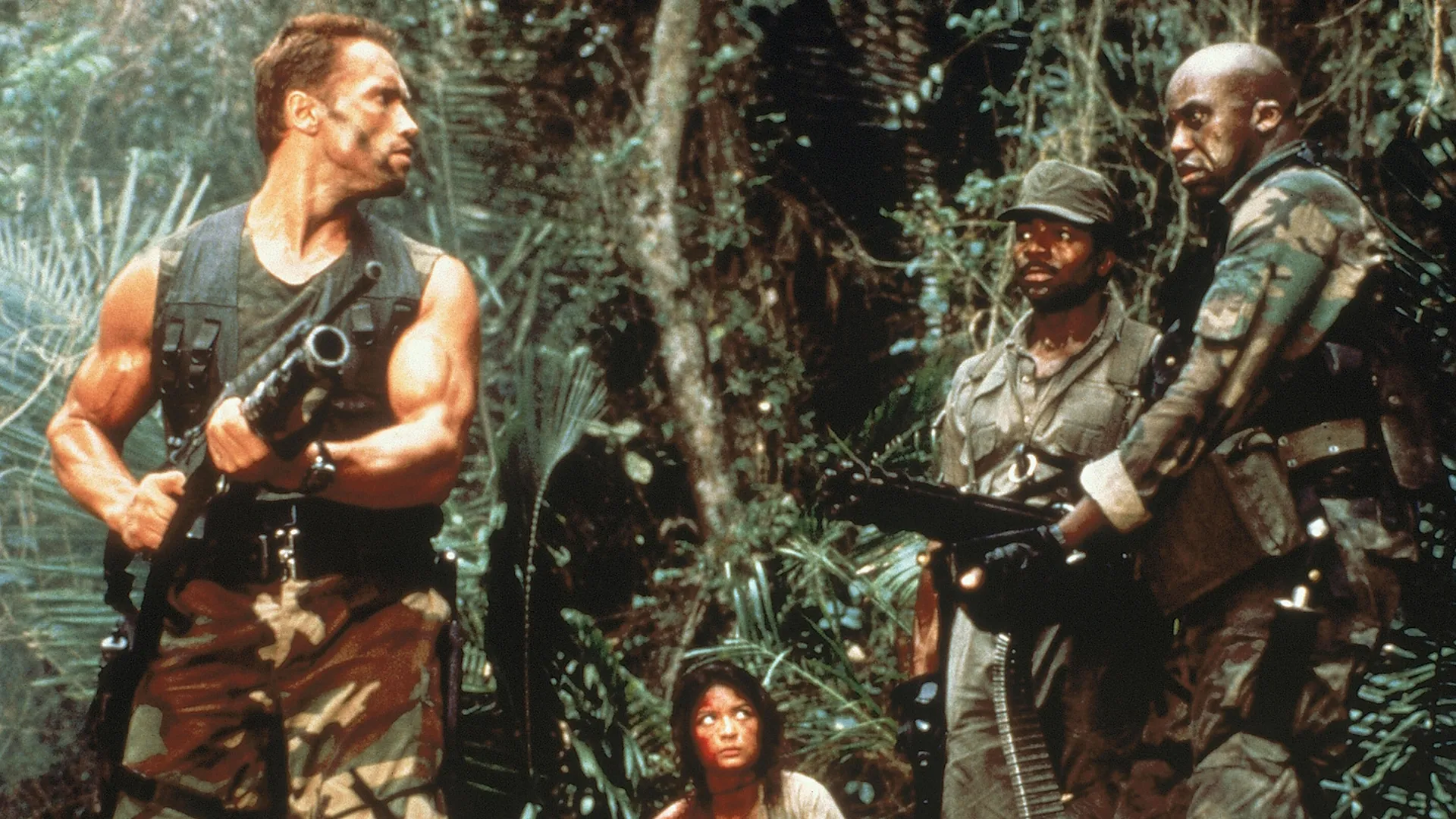Dutch, Anna, Dillon, and Mac traverse the jungle with their weapons in Predator.