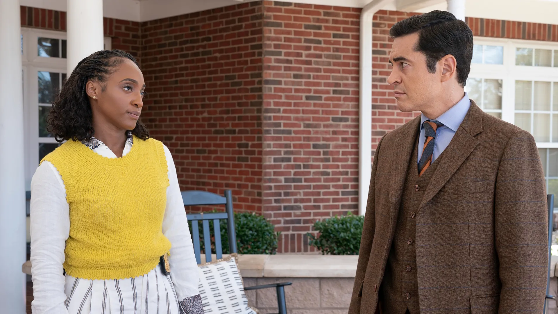 Faith Mitchell (Iantha Richardson) and Will (Ramón Rodríguez) stand on a porch looking at each other.
