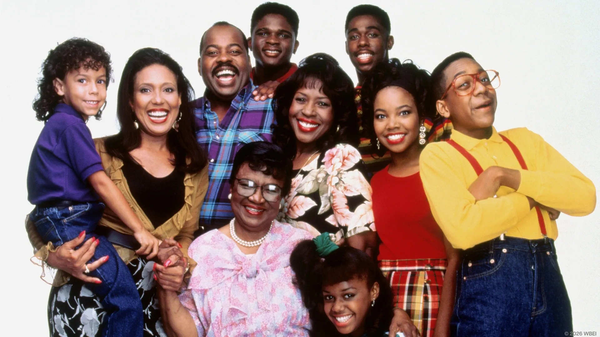 A cast promotional photo for the sitcom Family Matters features the Winslow family and Steve Urkel (Jaleel White) smiling together against a plain white background, with Carl (Reginald VelJohnson) and Harriette (Jo Marie Payton) at the center, surrounded by Eddie (Darius McCrary), Laura (Kellie Shanygne Williams), Judy (Jaimee Foxworth), Richie (Bryton James), Rachel (Telma Hopkins), and Mother Winslow (Rosetta LeNoire).