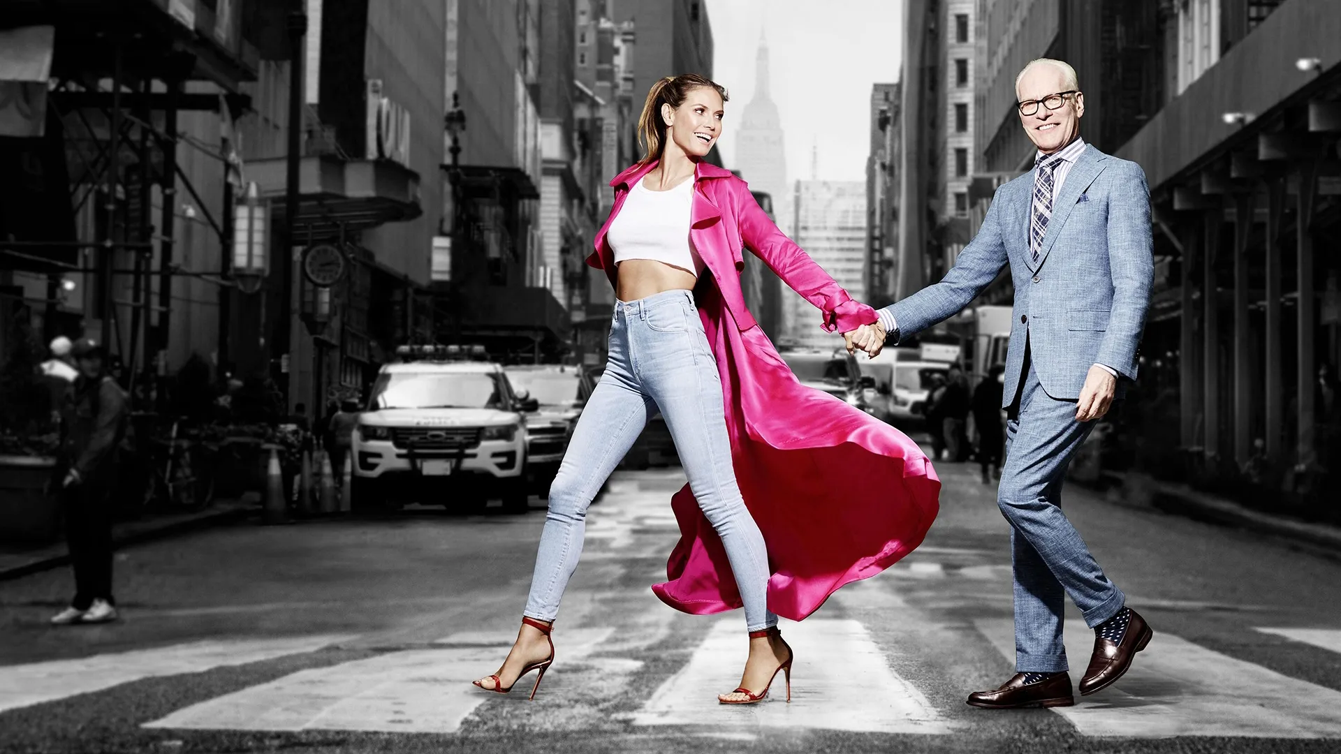 Project Runway hosts Heidi Klum and Timm Gunn cross a road hnad-in-hand.