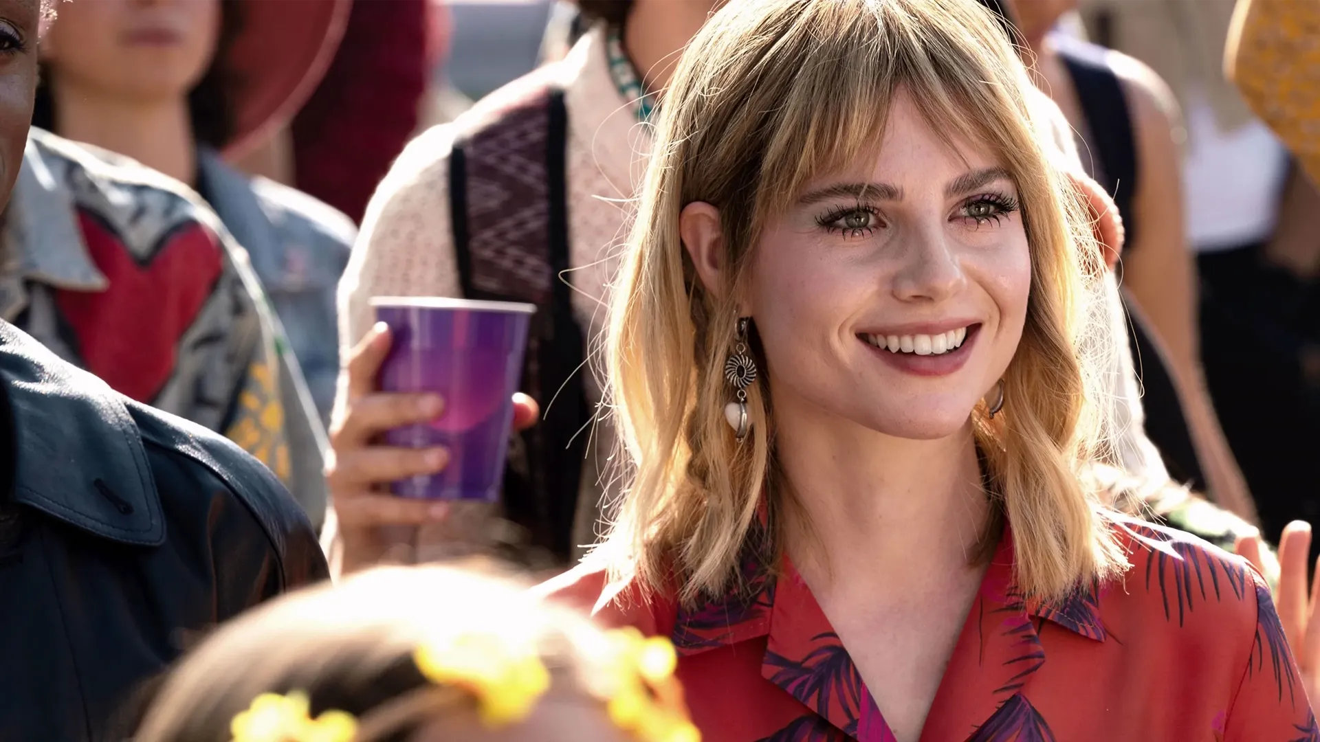 Harriet (Lucy Boynton) smiles in a crowd.