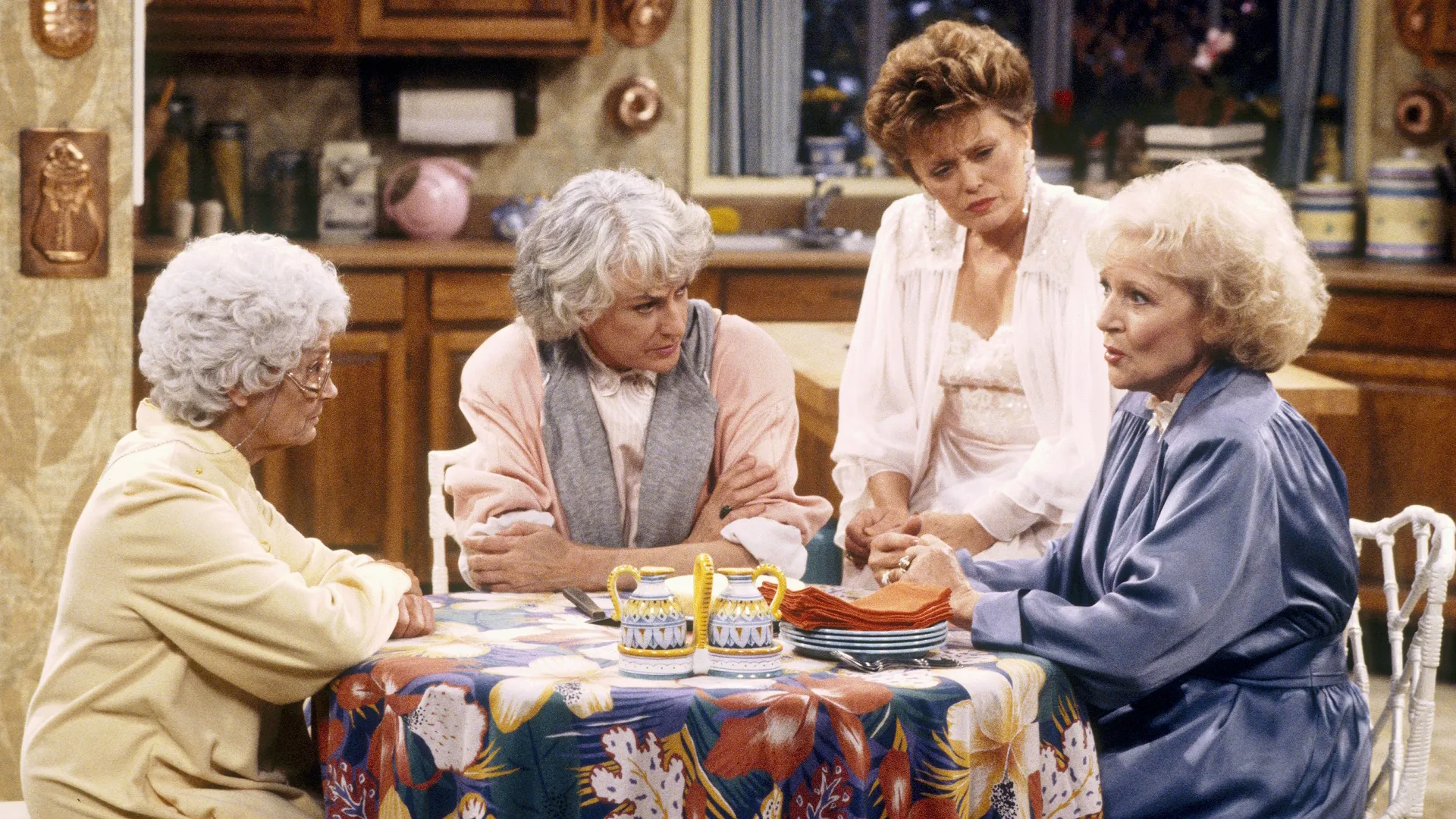 The Golden Girls beam as they pose for a picture, showcasing their close relationship and lively characters in a happy moment.