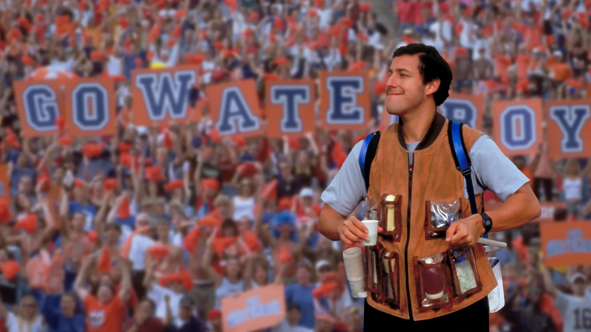 Bobby Boucher Jr. (Adam Sandler) standing in front of a cheering stadium crowd holding a sign that reads "GO WATERBOY."