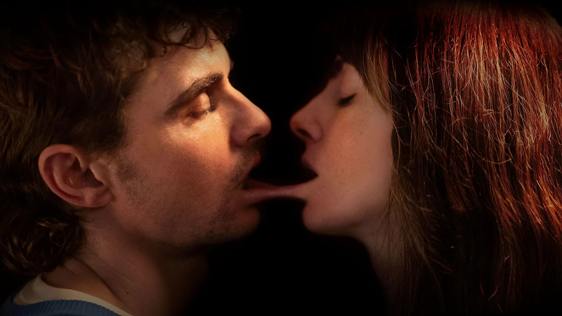 Dave Franco and Alison Brie with their bottom lips joined together as they attempt to kiss in Together.