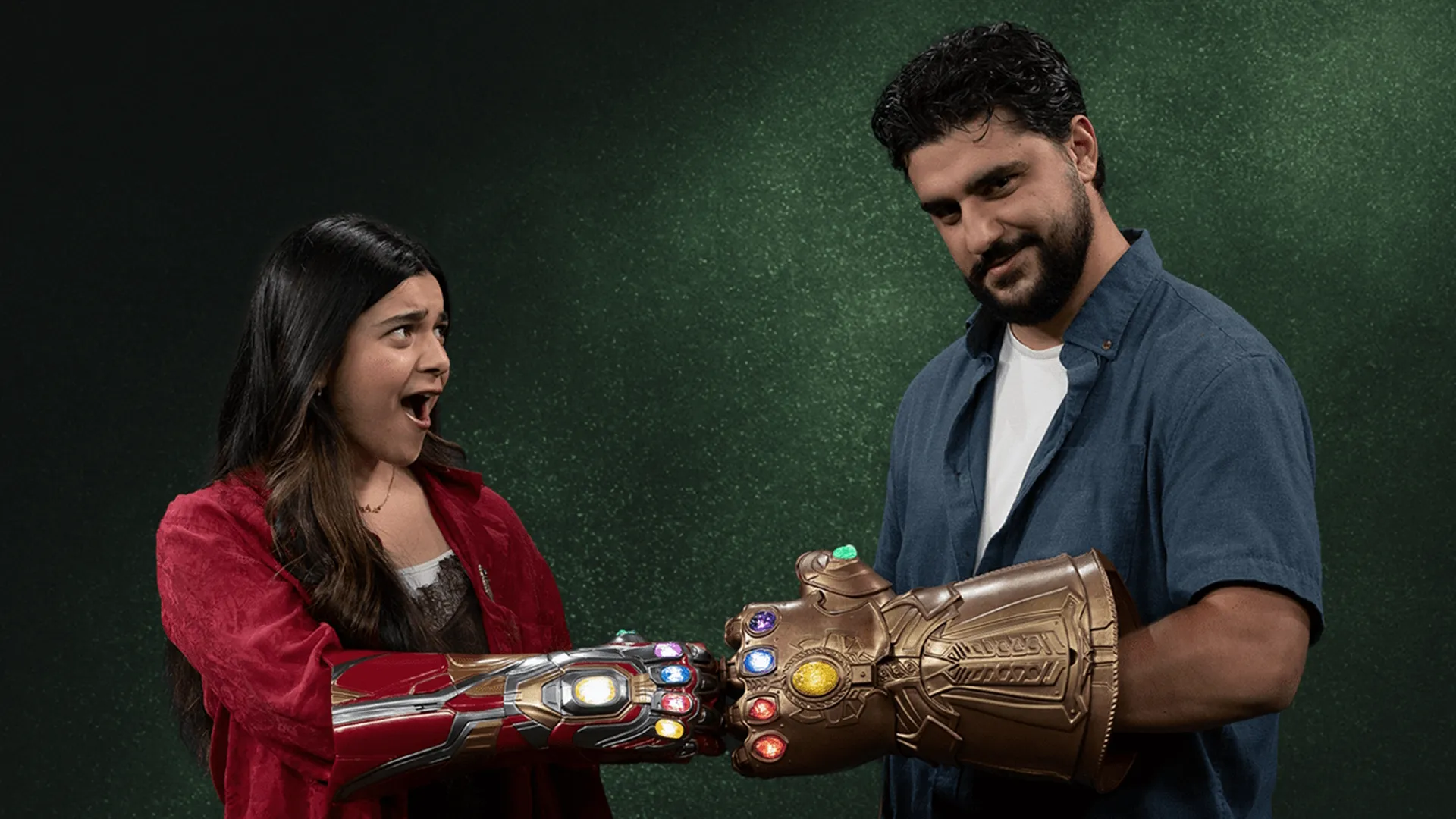 Countdown to Doomsday podcast hosts Iman Vellani and Frank Alvarez fist bump while wearing infinity gauntlets.