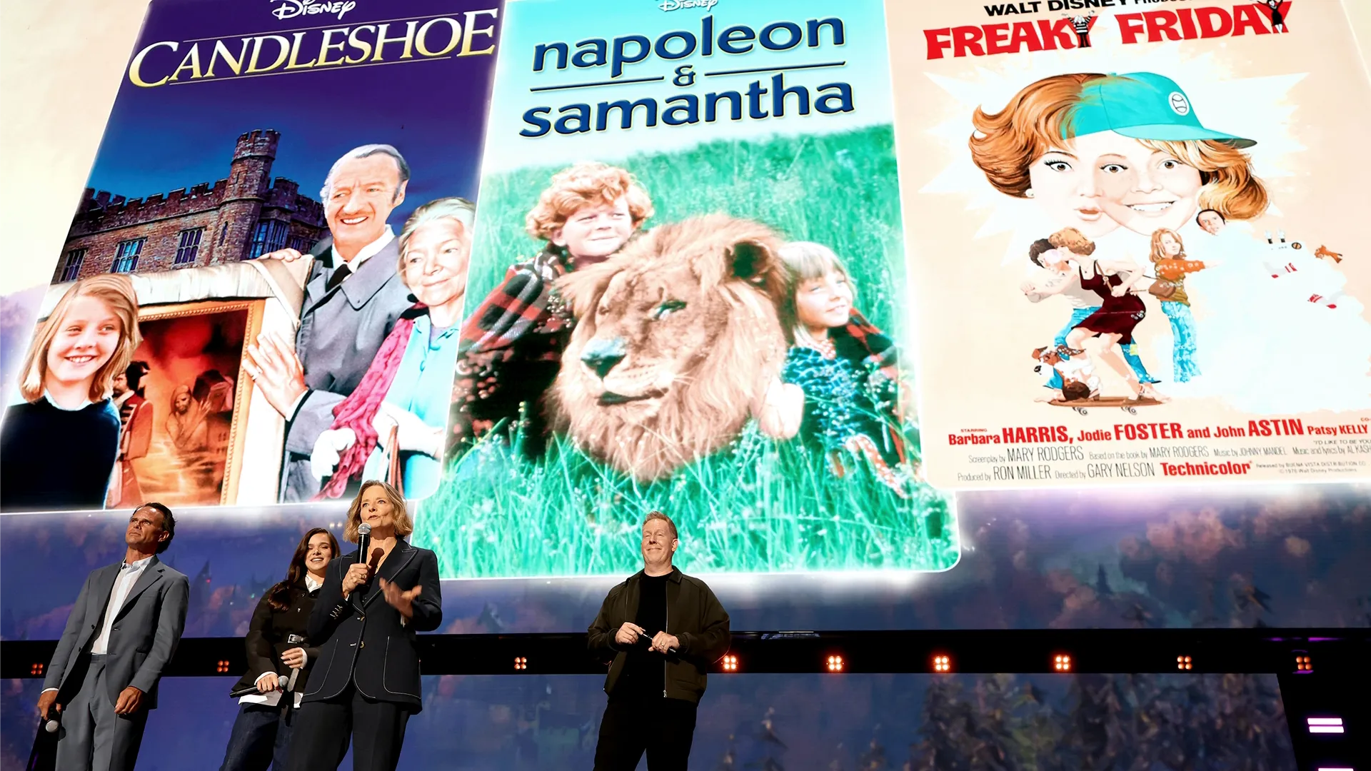 An on-stage presentation in front of posters for Candleshoe, Napoleon & Samantha, and Freaky Friday (1976)