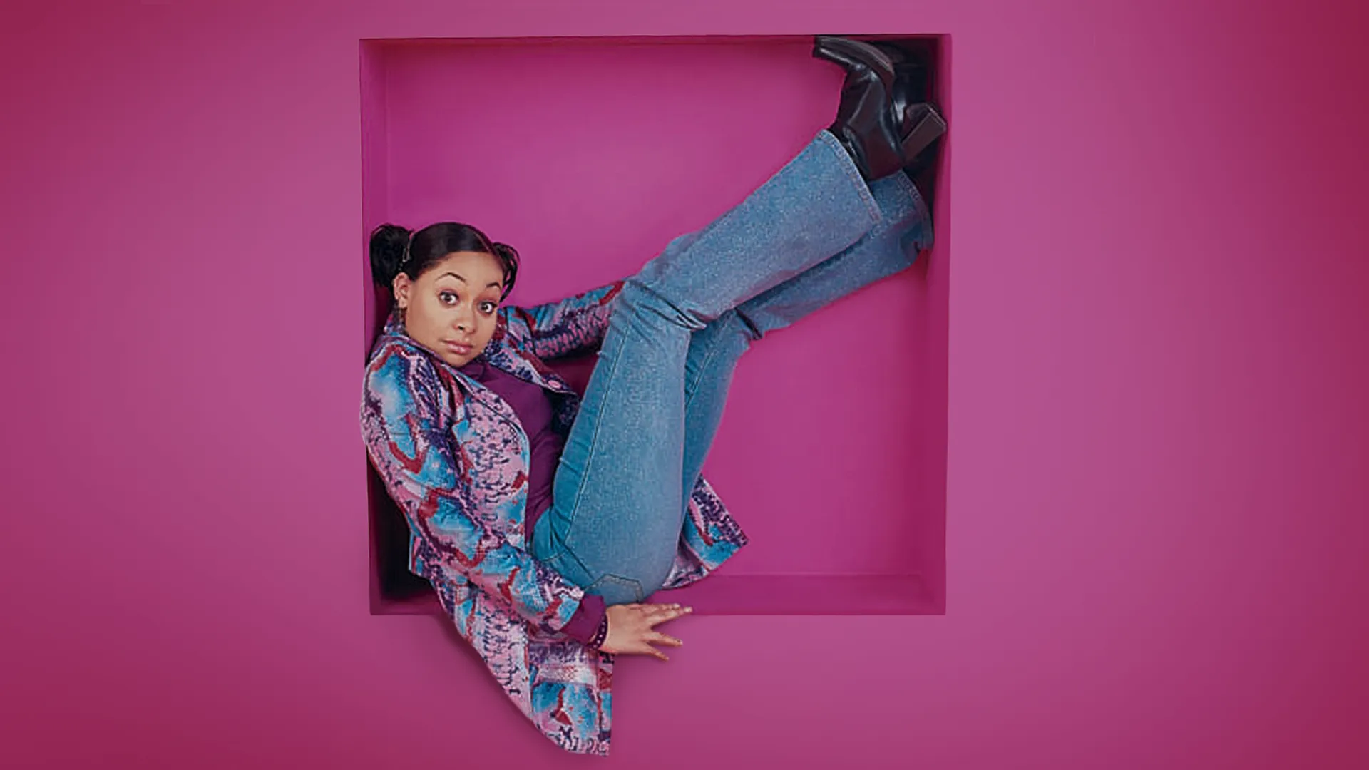 Raven (Raven-Symoné) sits in a pink alcove