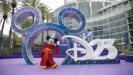 Mickey Mouse poses outside the entrance to D23: The Ultimate Disney Fan Event