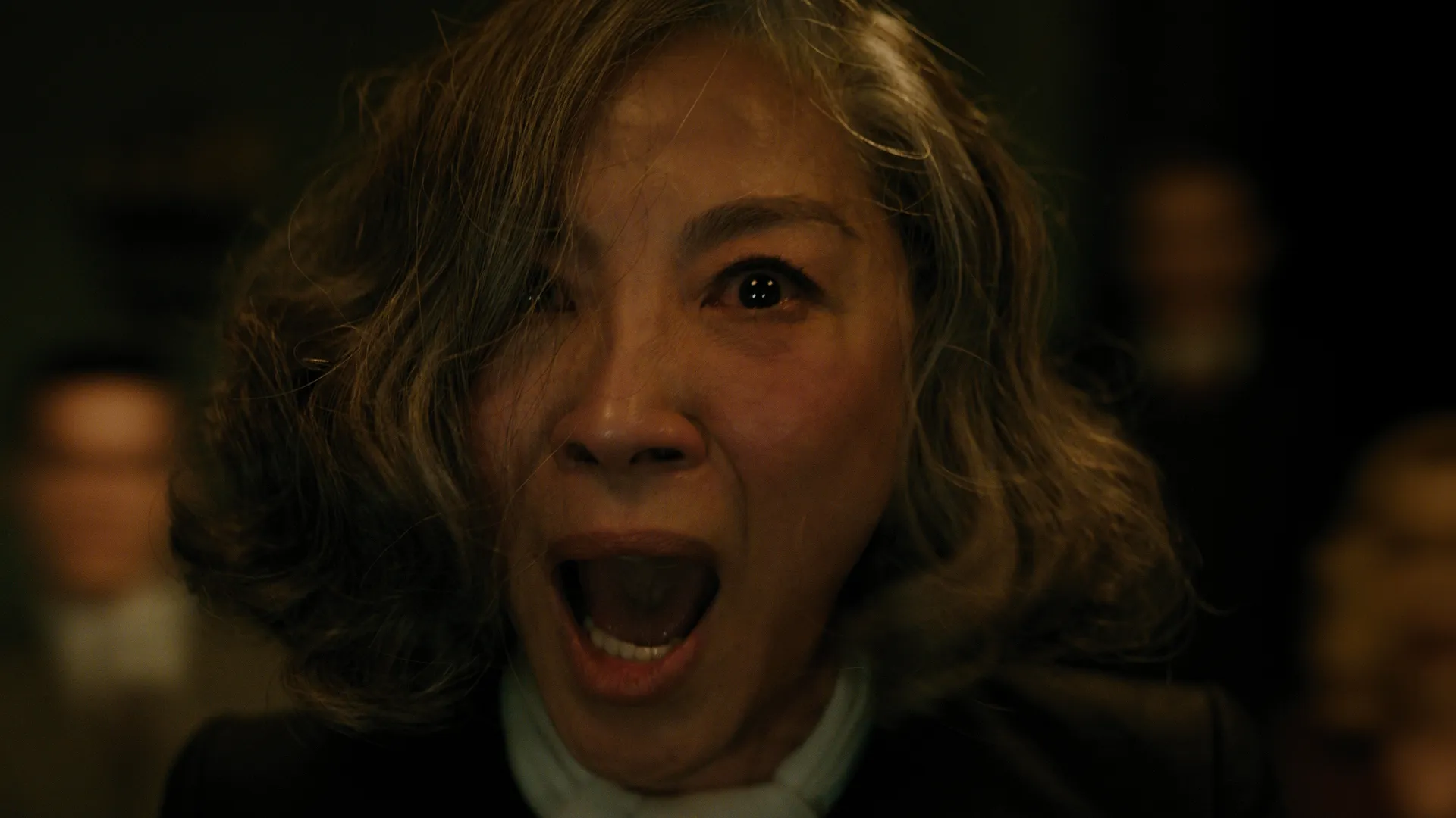 Joyce Reynolds (Michelle Yeoh) lets out a chilling scream with her eyes wide open in horror in A Haunting In Venice.