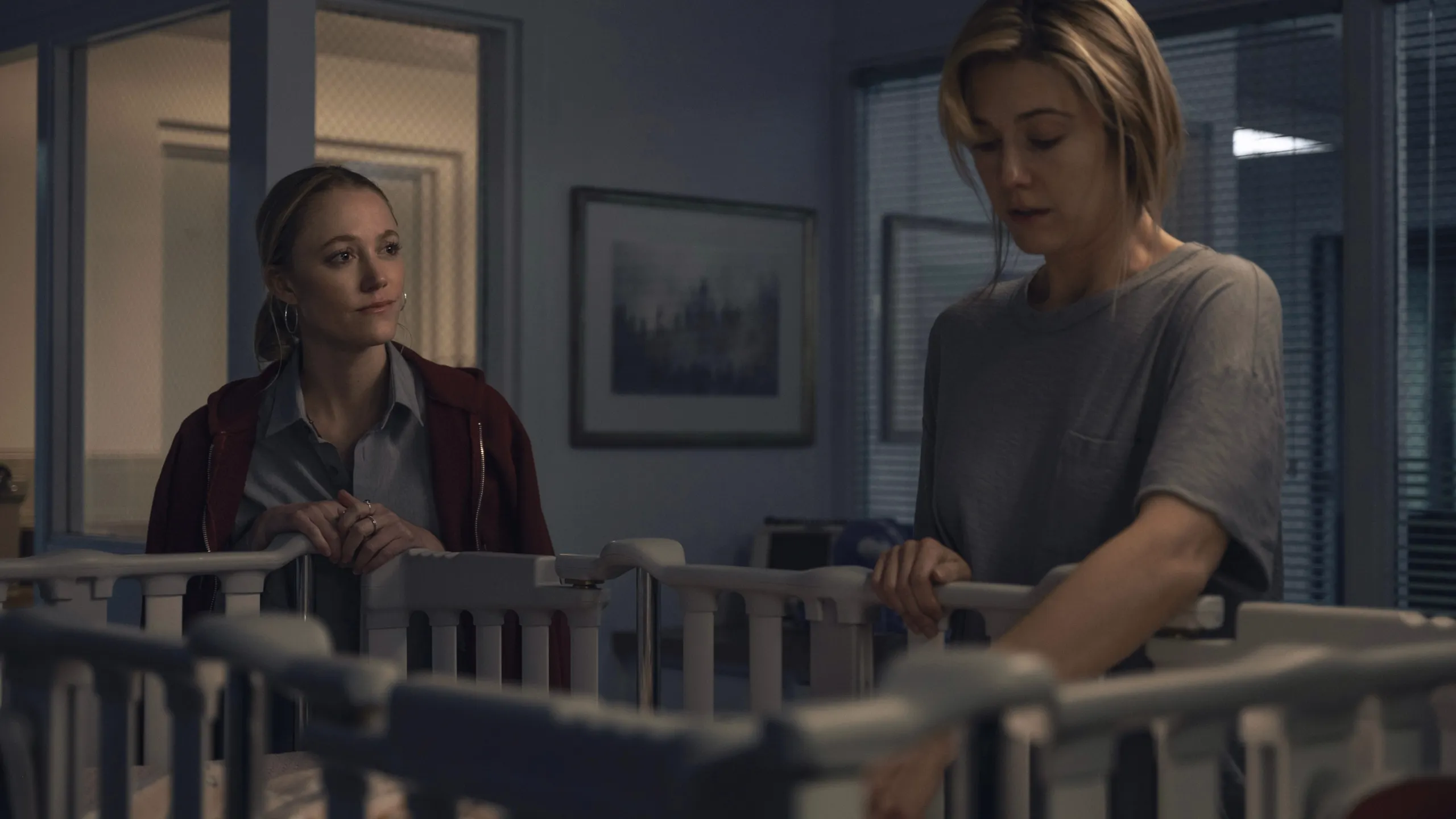 Polly Murphy (Maika Monroe) and Caitlin Morales (Mary Elizabeth Winstead) stand beside a cradle.