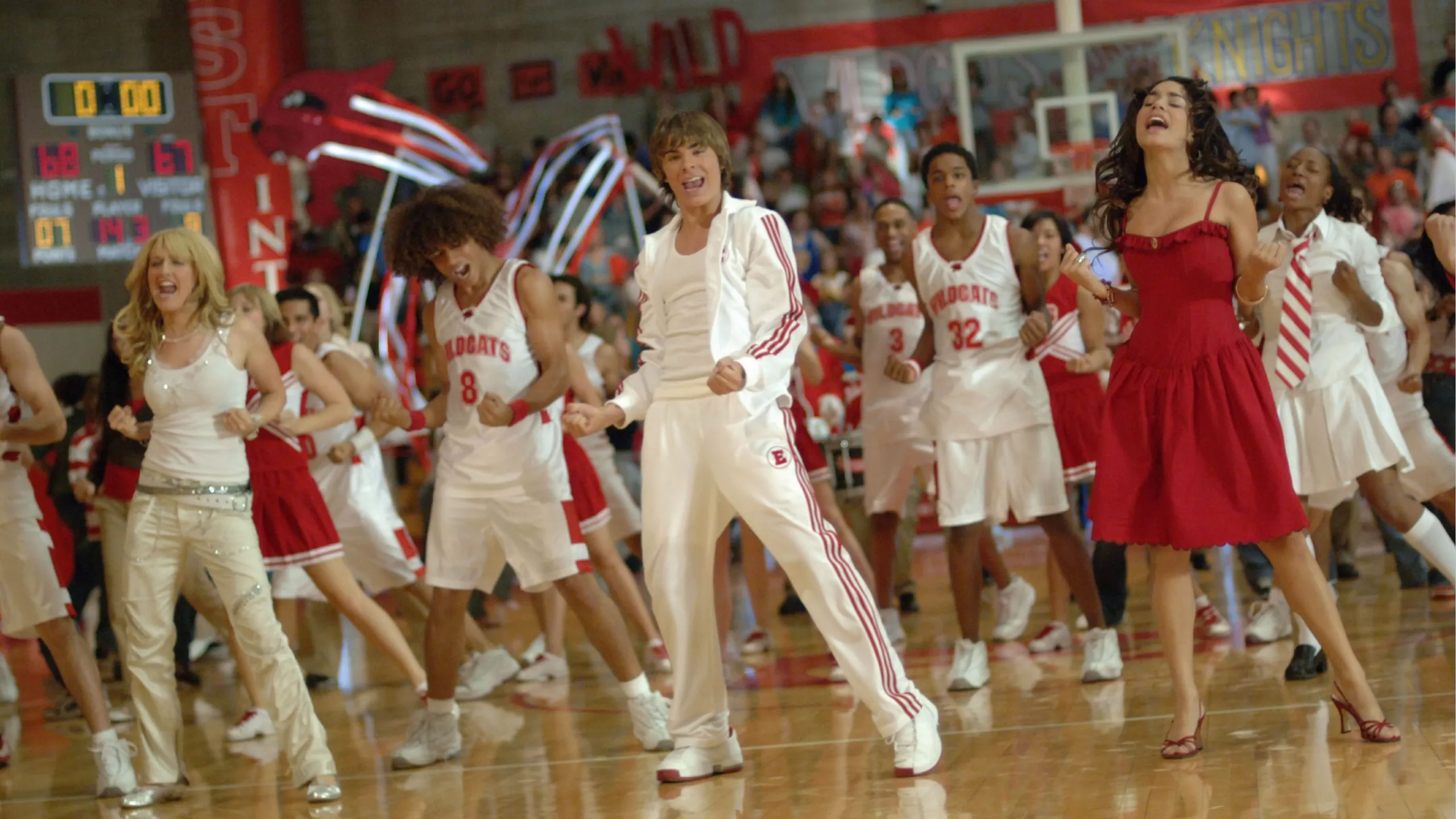 The cast of High School Musical dancing in the school gymnasium