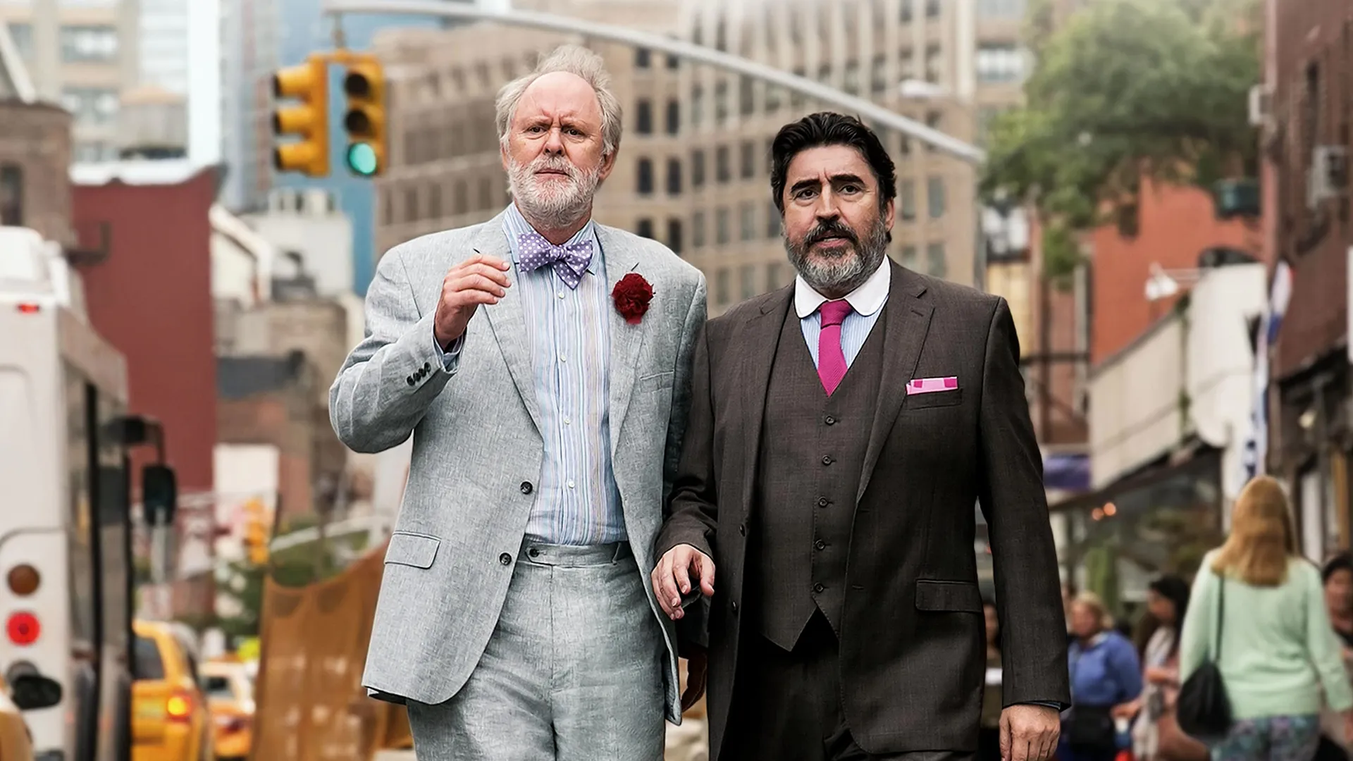 Ben (John Lithgow) and George (Alfred Molina) stand on a busy sidewalk, dressed in suits