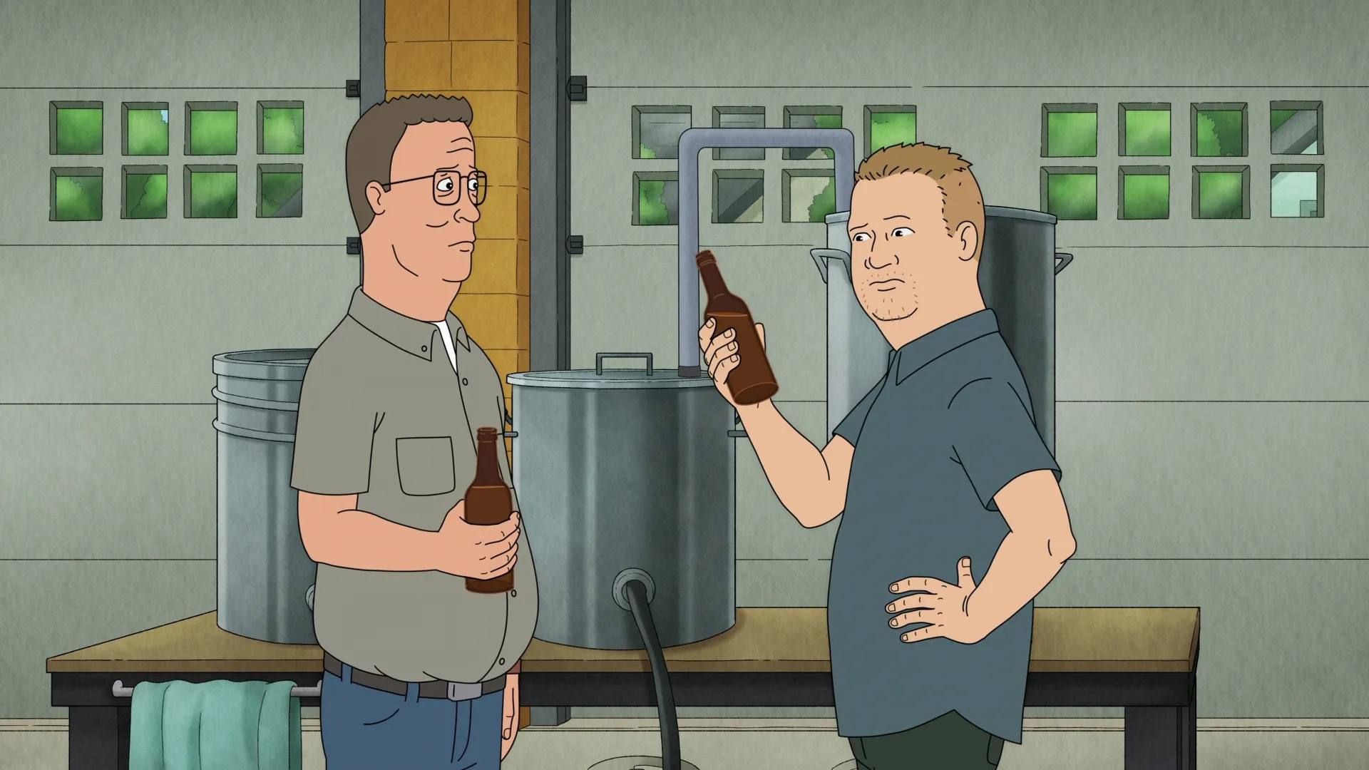 Hank (Mike Judge) and Bobby (Pamela Adlon) hold beer bottles beside home-brewing equipment.