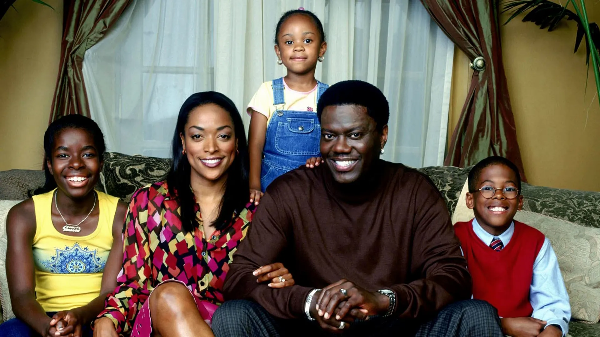 Bernie Mac sitting on a sofa with his family
