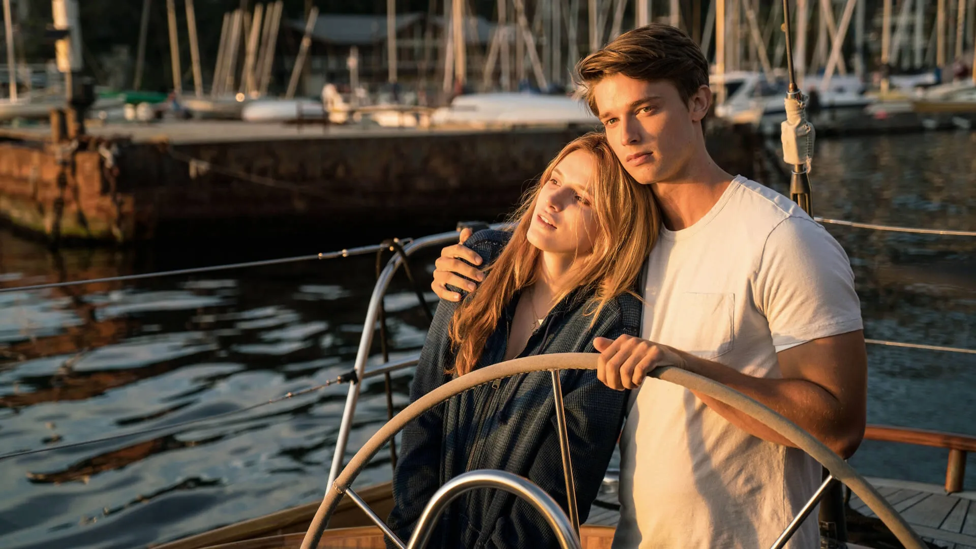 Katie (Bella Thorne) huddles up to Charlie (Patrick Schwarzenegger) as he steers a boat through a harbor