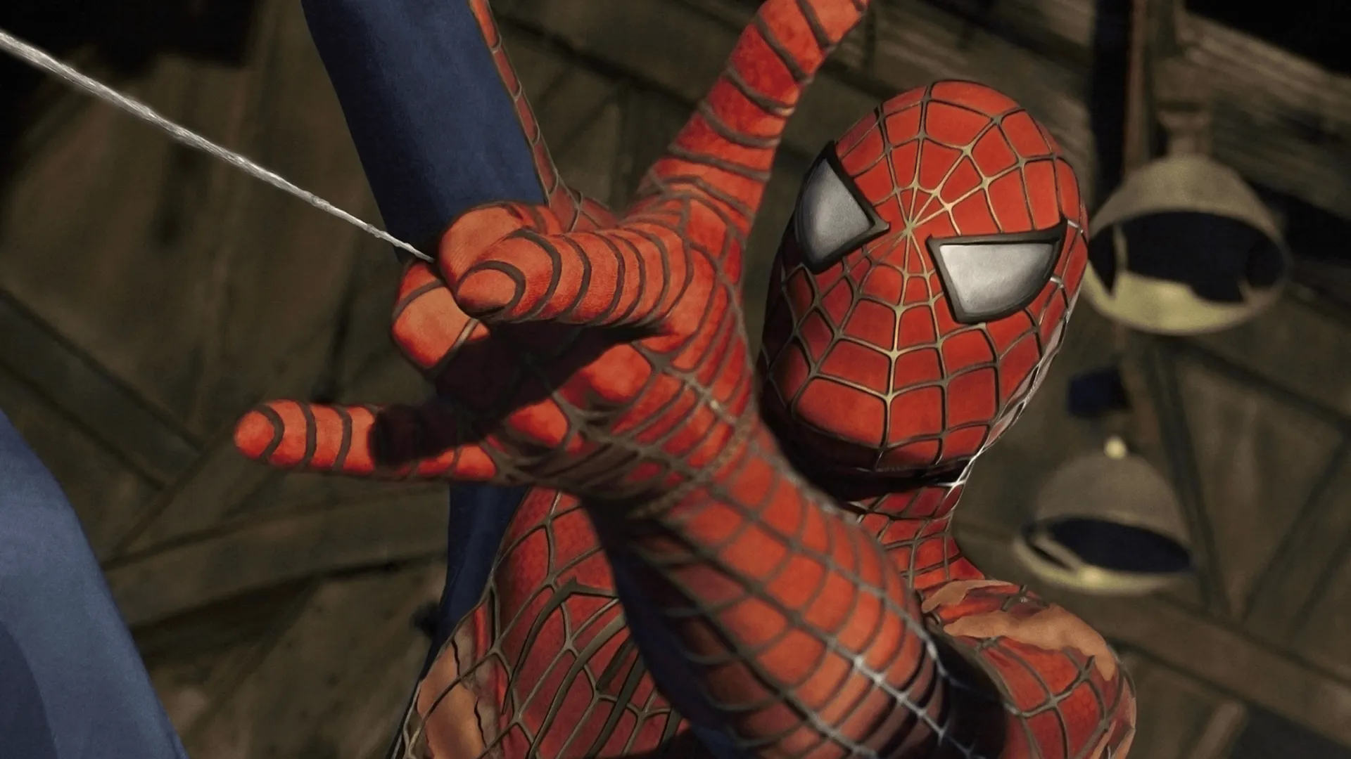 Tobey Maguire as Spider-Man shooting a web from his wrist in his classic red and blue suit from Sam Raimi's 2002 Marvel superhero film Spider-Man.