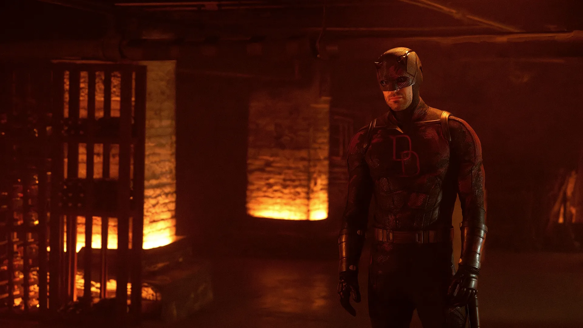 Daredevil (Charlie Cox) stands inside a burning building.