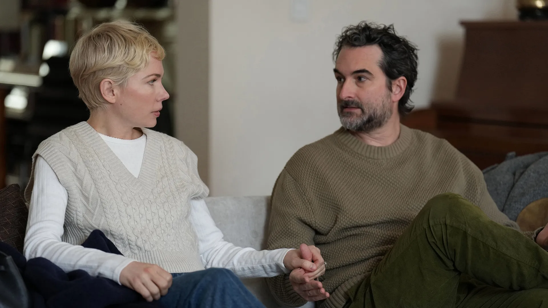 Molly (Michelle Williams) and Steve (Jay Duplass) sit on a couch holding hands