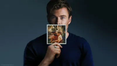 Chris Hemsworth holding up a family photograph.