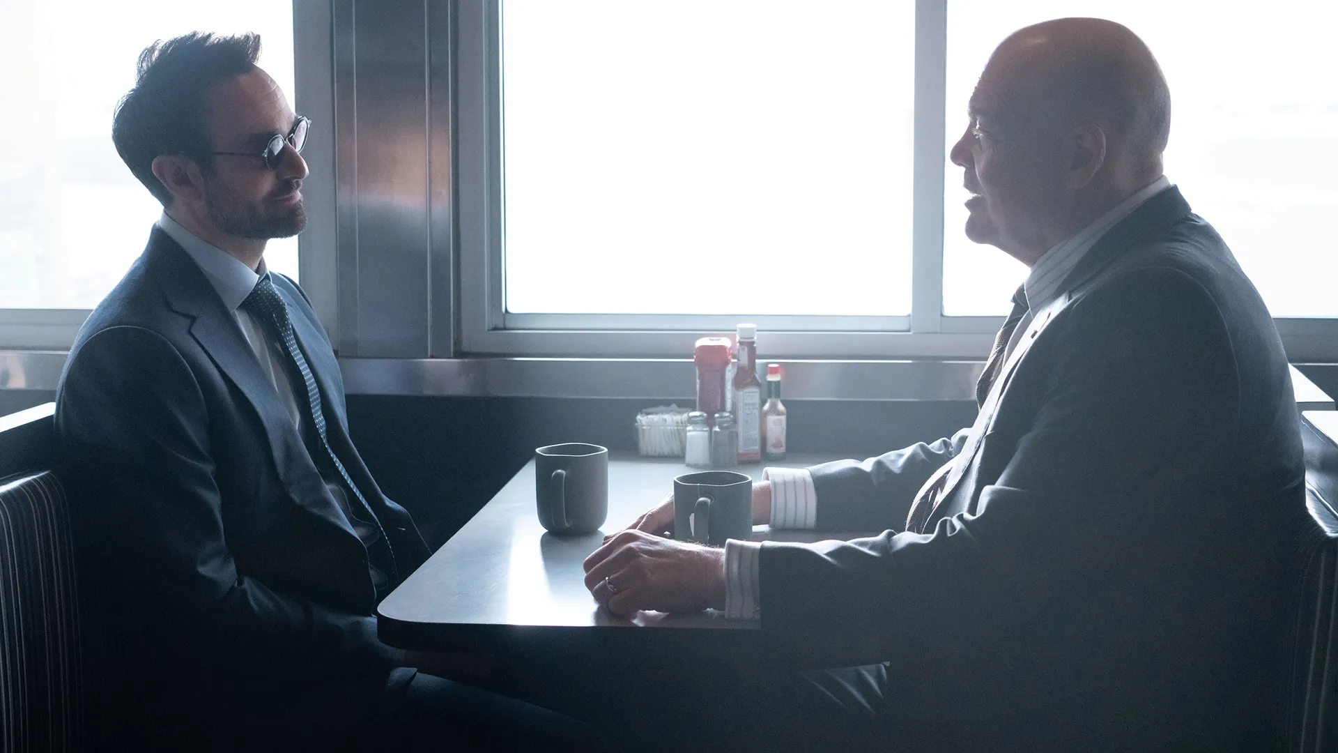 Matt Murdock (Charlie Cox) sits across from Wilson Fisk (Vincent D'Onofrio) in a diner.