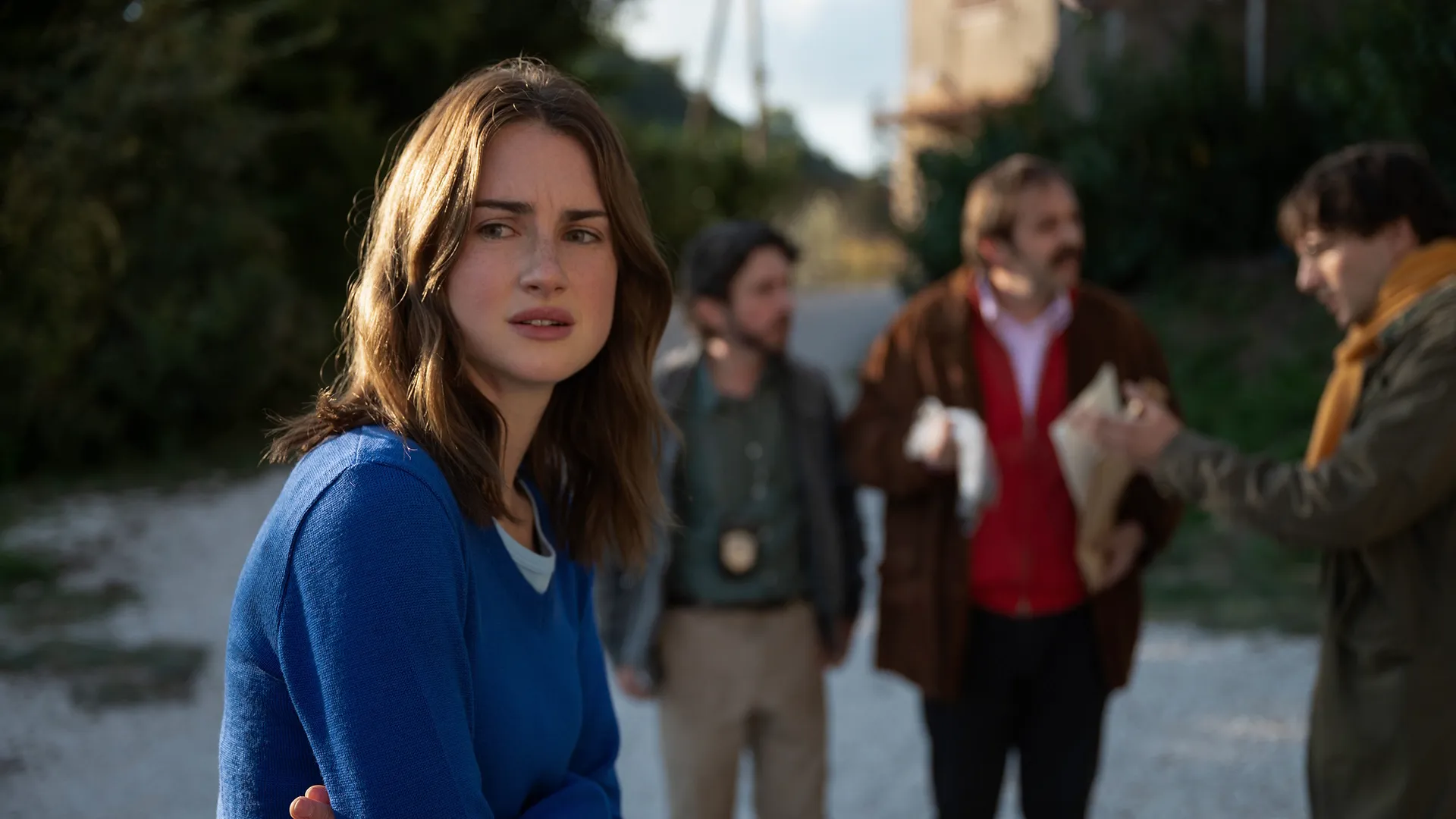 Amanda Knox with detectives in the background.