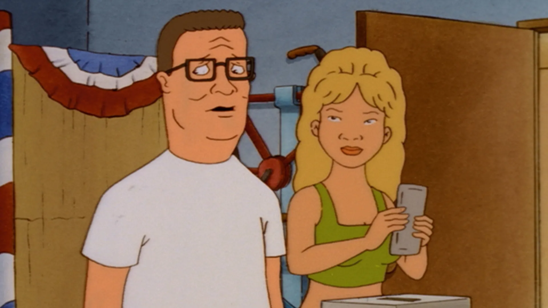 Hank (Mike Judge) looks uneasy beside Luanne (Brittany Murphy), who holds a ballot in a room decorated with patriotic bunting.