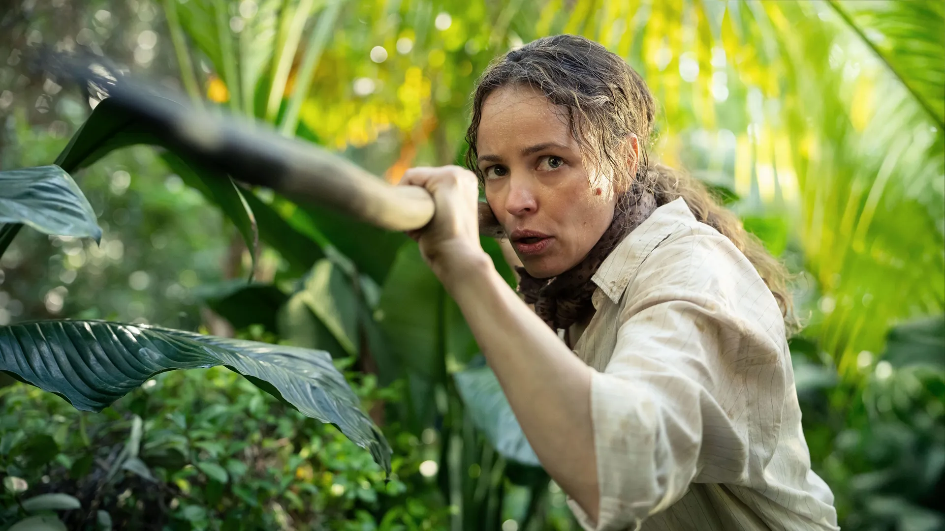 Rachel McAdams como Linda Liddle, empunhando um grande bastão enquanto caça javalis.