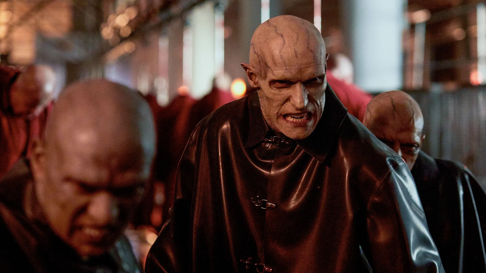 Three scary looking, bald men with visible blue veins on their heads and faces