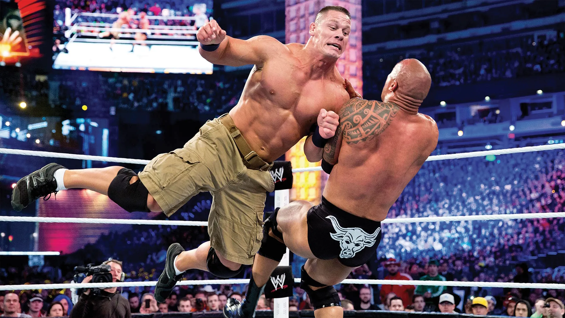 John Cena wrestles Randy Orton in the ring.