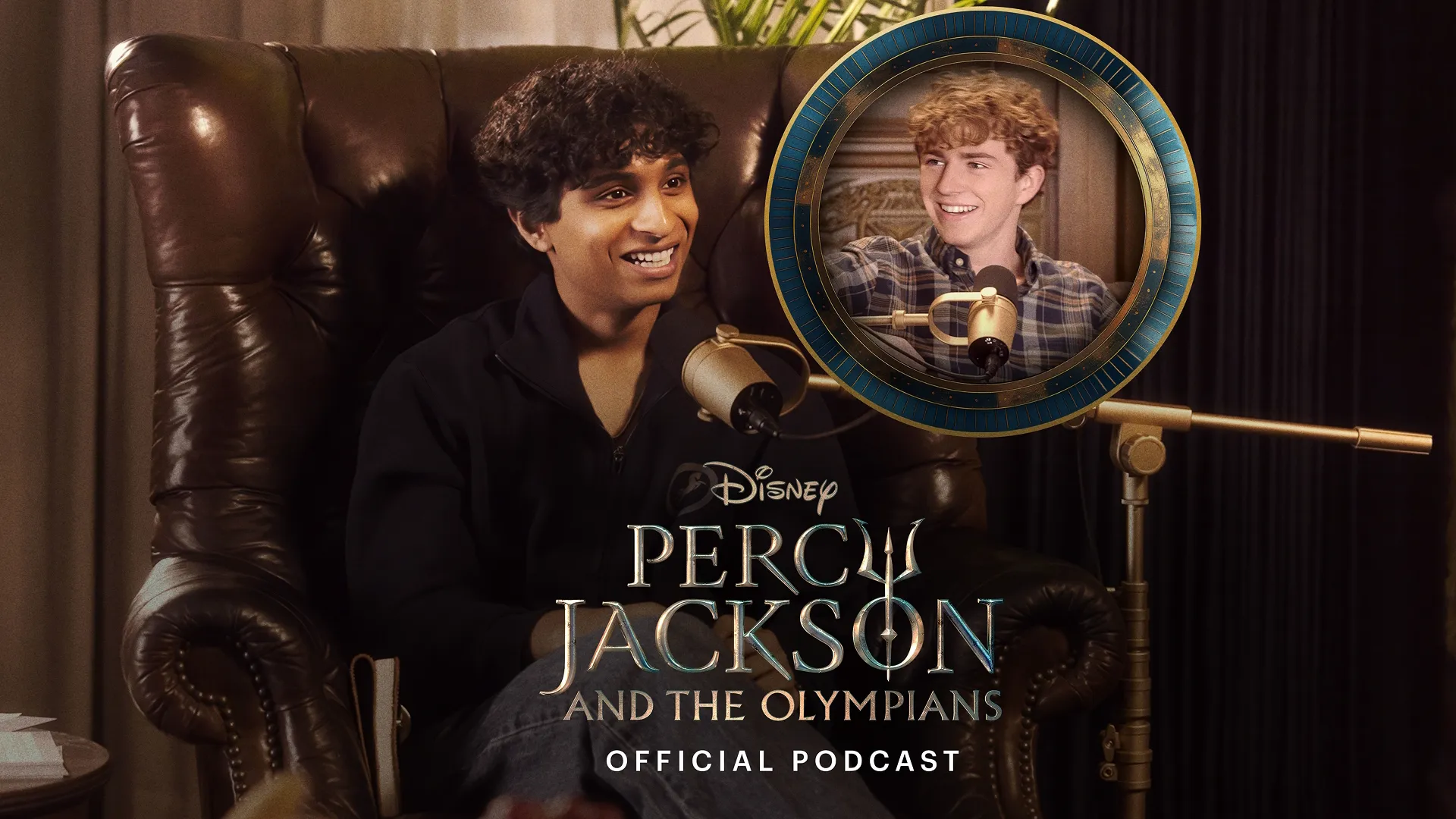 Podcast host Aryan Simhadri, who plays Grover in the series, sitting in a leather chair with a mic talking with Walker Scobell, who plays Percy Jackson.