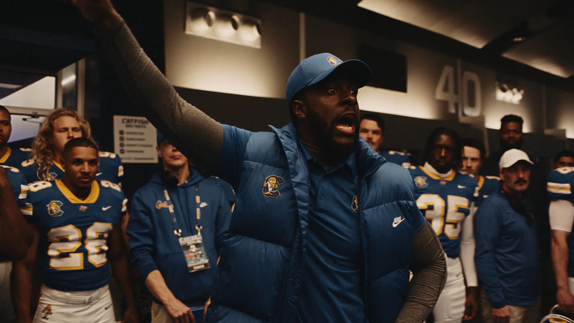 Coach Byrd (Quentin Plair) gives the team a pep talk in the locker room.