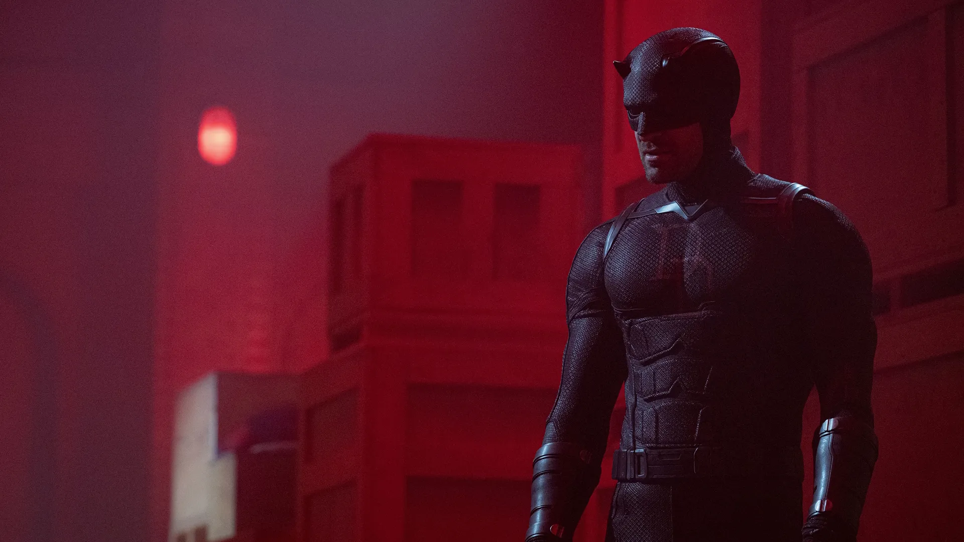 Matt Murdock/Daredevil (Charlie Cox) in a room with red lighting that's filled with boxes.