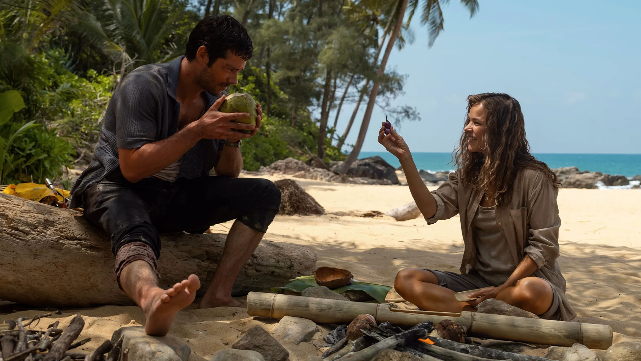 Linda Liddle (Rachel McAdams) na praia com seu chefe Bradley (Dylan O'Brien) após o acidente de avião.