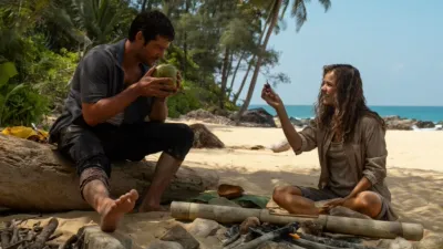 Linda Liddle (Rachel McAdams) on the beach with her boss Bradley (Dylan O'Brien) after the plane crash.