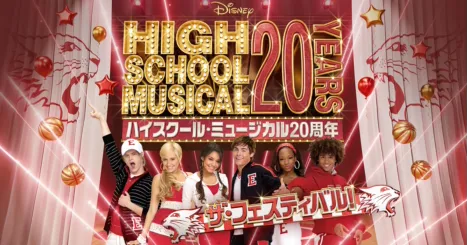 Here's alt text in Japanese:  **ディズニー「ハイスクール・ミュージカル」20周年記念フェスティバルの告知バナー。赤と金色のデザインに、主要キャストが笑顔でポーズを取っている。テキスト：「ハイスクール・ミュージカル20周年 ザ・フェスティバル！」**  And a slightly more concise version if needed:  **「ハイスクール・ミュージカル20周年 ザ・フェスティバル！」キャストが登場するディズニーの記念キャンペーンバナー**