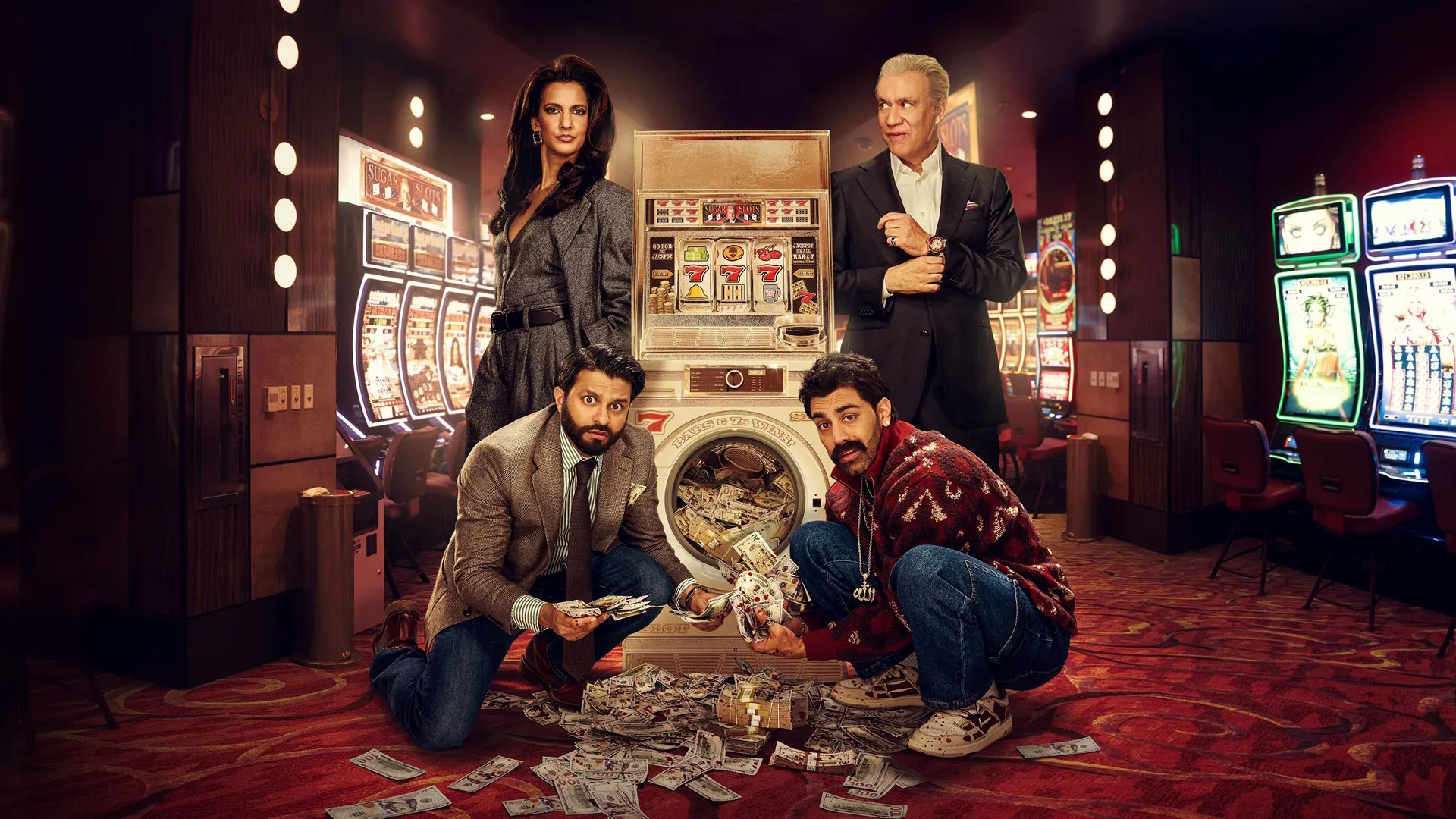 Lucky, Raj, Mir, and Max stand in a casino, by a slot machine-laundry machine hybrid with cash spilling out of it